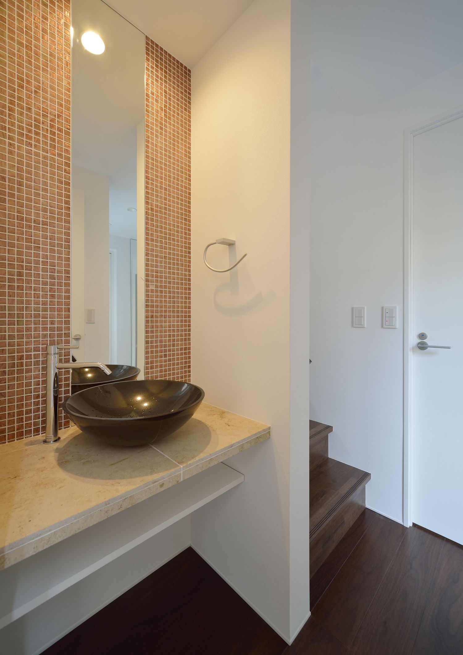 タイルのアクセントウォールに鏡が取り付けられた手洗いカウンター・デザイン住宅