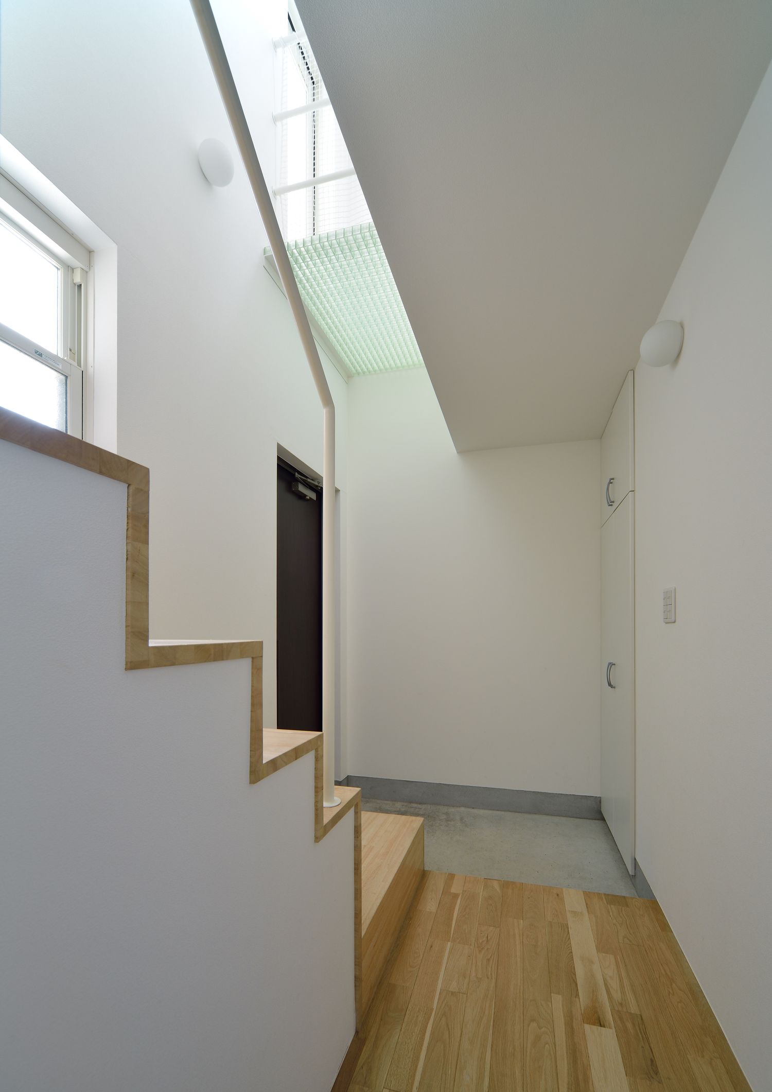 玄関のそばにある吹き抜けの開放的な階段・デザイン住宅