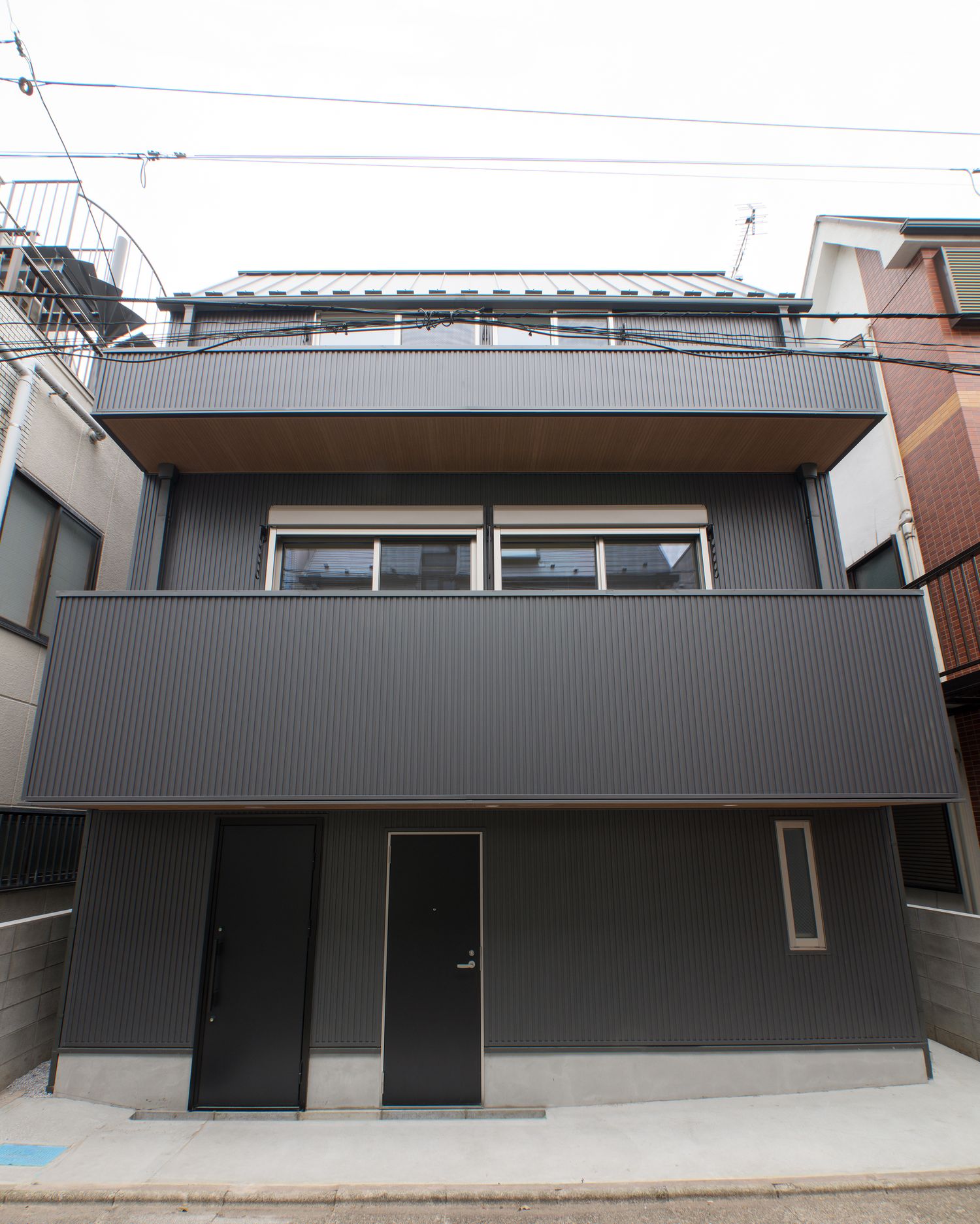 住宅地に建つ、バルコニーのある黒い外壁の住宅・デザイン住宅 注文住宅・デザイン住宅建築実例_『CASE549 招きの家』_外観