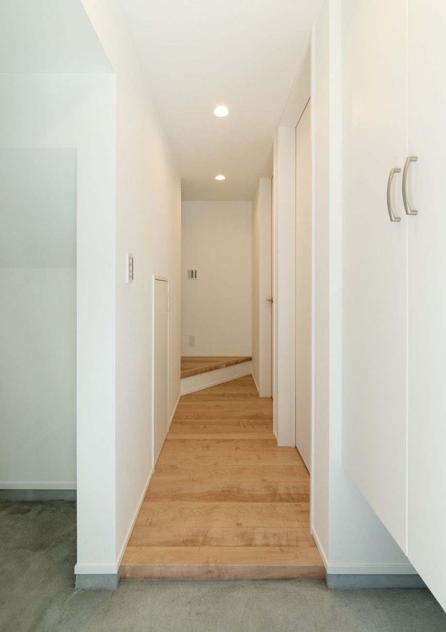 モルタルの玄関からフローリングの廊下が繋がる様子・デザイン住宅 注文住宅・デザイン住宅建築実例_『CASE549 招きの家』_玄関