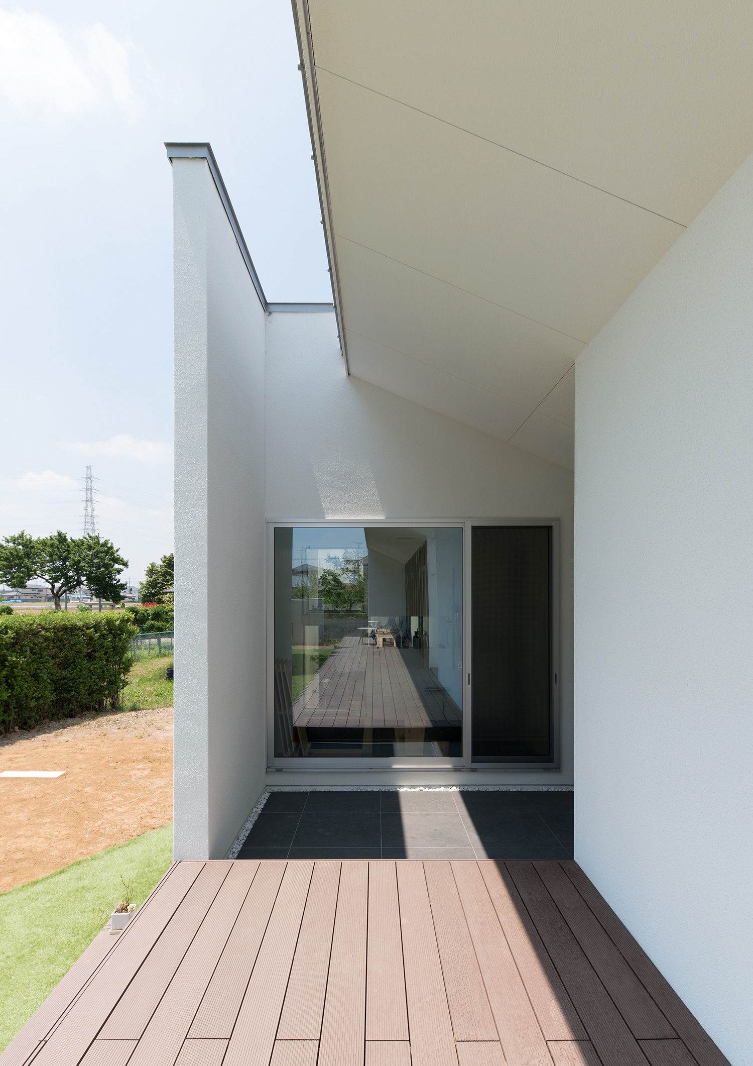 ウッドデッキのテラスから、渡り廊下を挟んで隣棟の様子が見える平屋住宅・デザイン住宅 注文住宅・デザイン住宅建築実例_『CASE634 アトリエを持つ家』_テラス・バルコニー