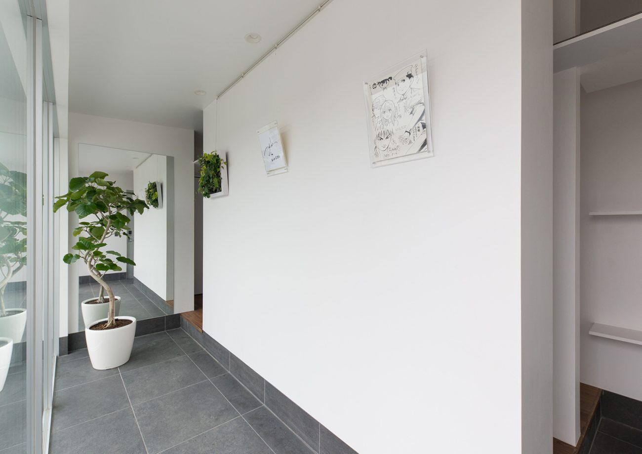 シューズインクローゼットと繋がる、観葉植物が置かれたグレーのタイルの玄関・デザイン住宅 注文住宅・デザイン住宅建築実例_『CASE634 アトリエを持つ家』_玄関