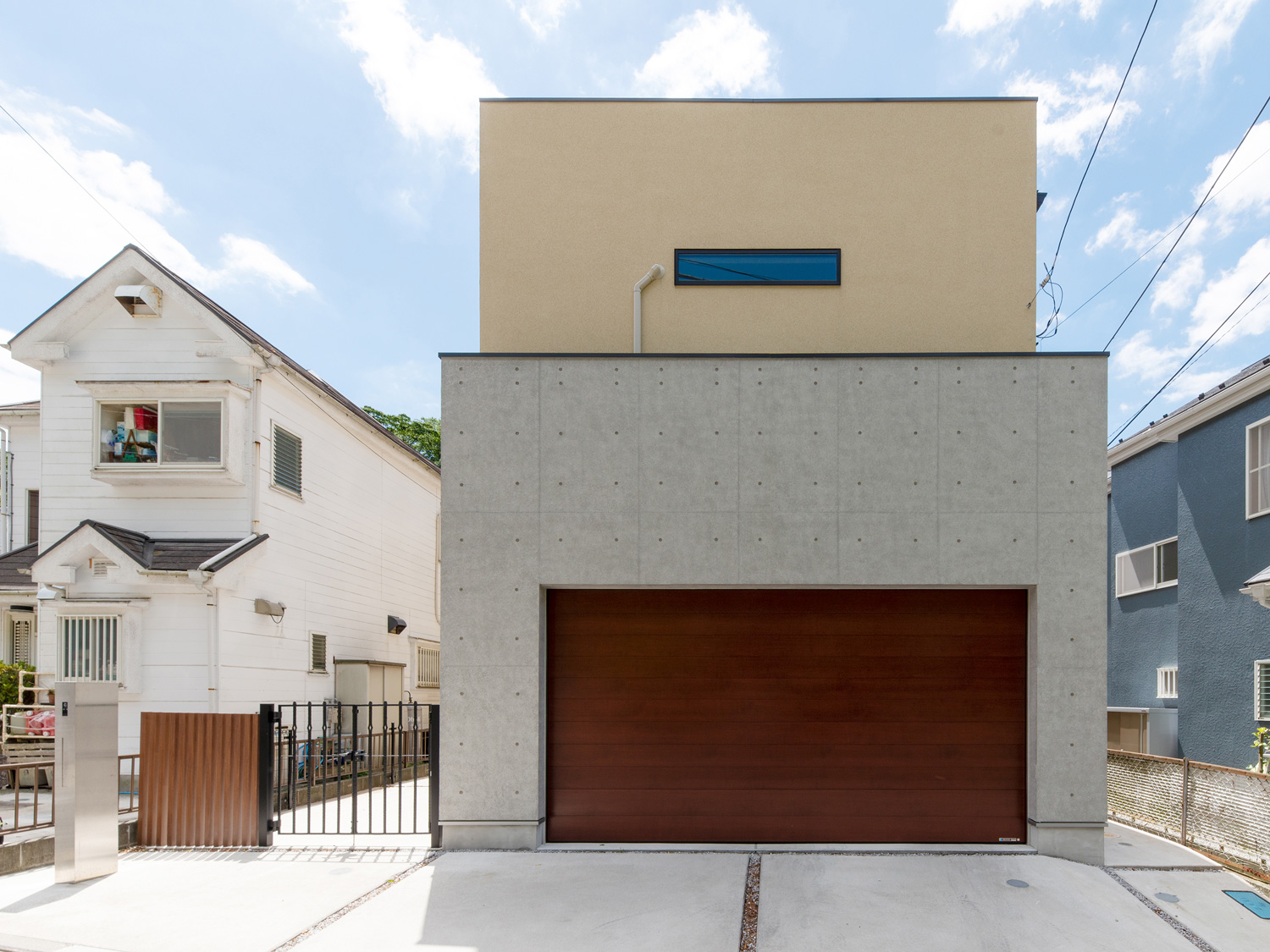 コンクリート打ちっ放し風の壁と塗りの壁を組み合わせた直線的な外観