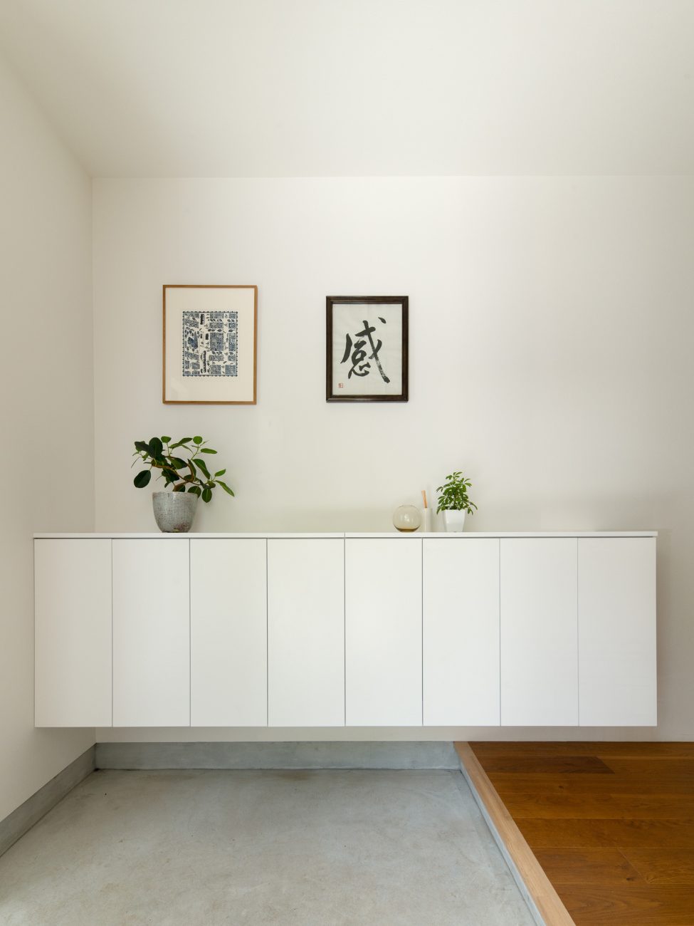 浮いたデザインの白いシューズボックスの上に観葉植物が飾られた玄関・デザイン住宅 注文住宅・デザイン住宅建築実例_『CASE637 『Assemble』』_玄関