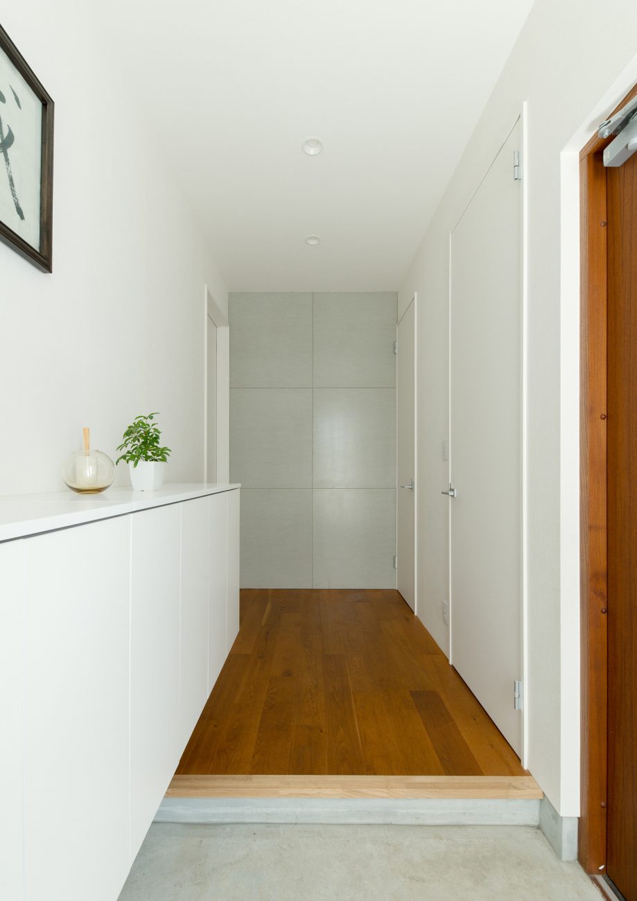 モルタルの玄関から白い壁でフローリングの廊下が見える様子・デザイン住宅 注文住宅・デザイン住宅建築実例_『CASE637 『Assemble』』_玄関