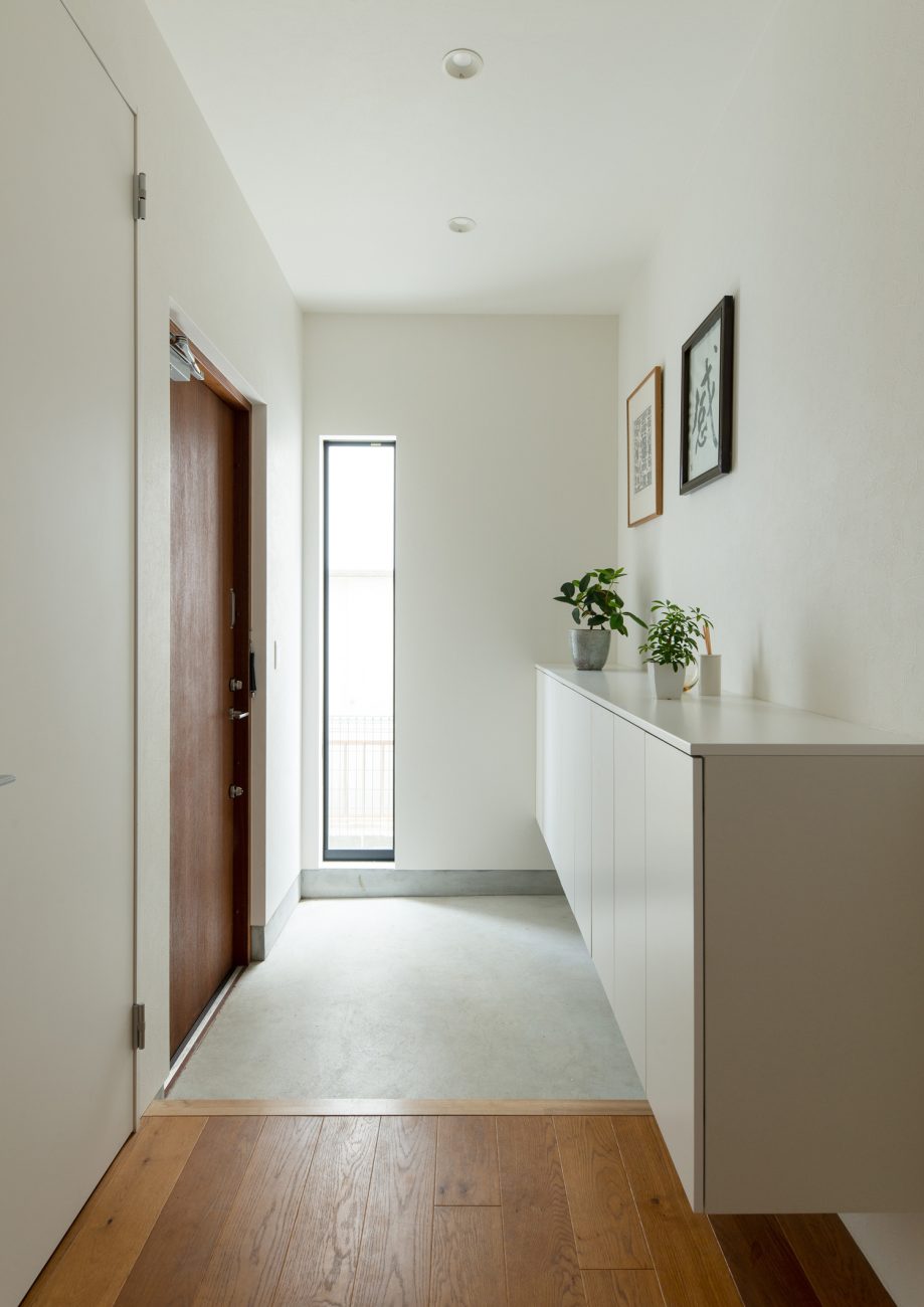 縦長のスリット窓があるモルタルの玄関・デザイン住宅 注文住宅・デザイン住宅建築実例_『CASE637 『Assemble』』_玄関