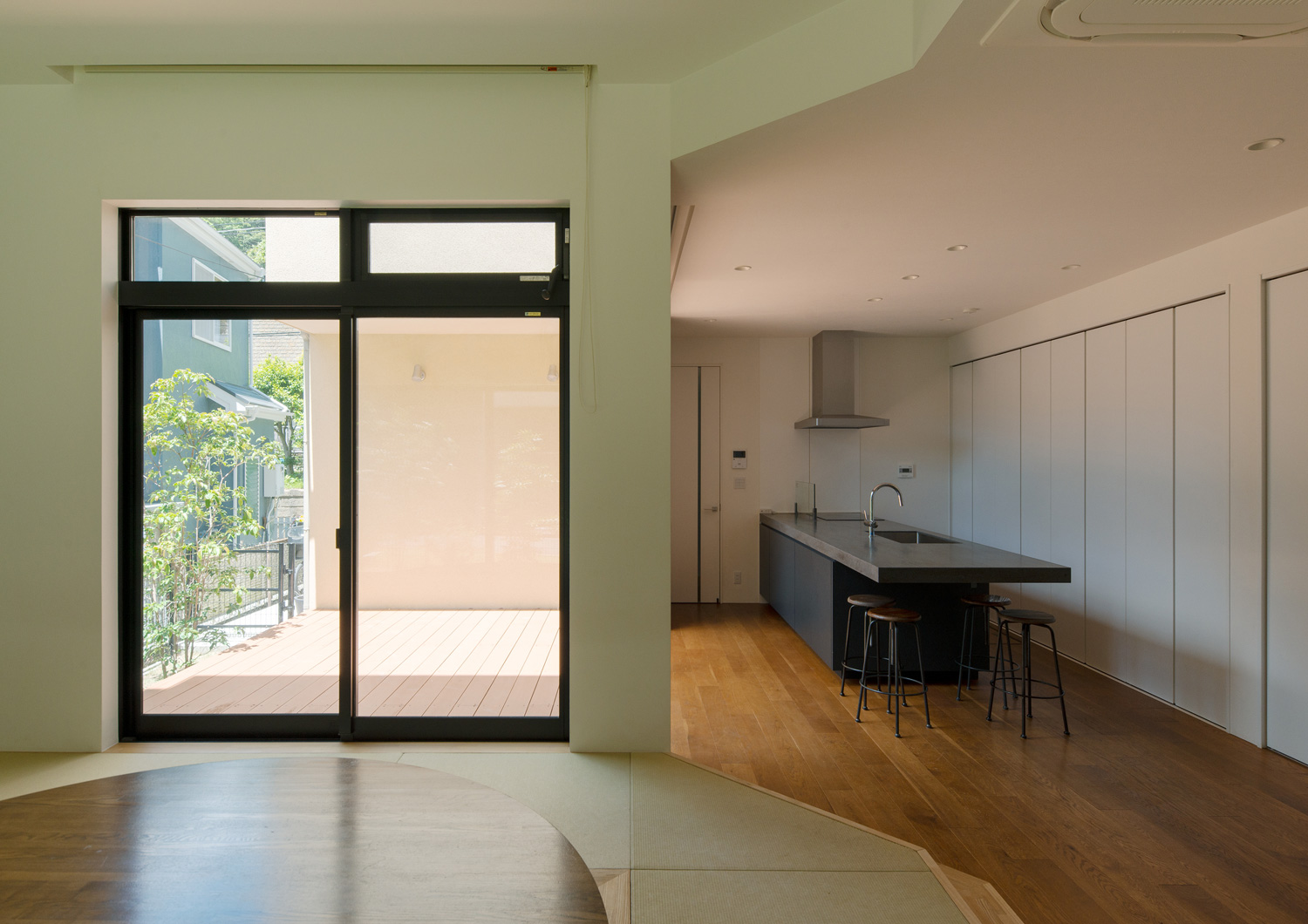 ウッドデッキの中庭に繋がる大きな窓がある畳のリビング・デザイン住宅 注文住宅・デザイン住宅建築実例_『CASE637 『Assemble』』_LDK