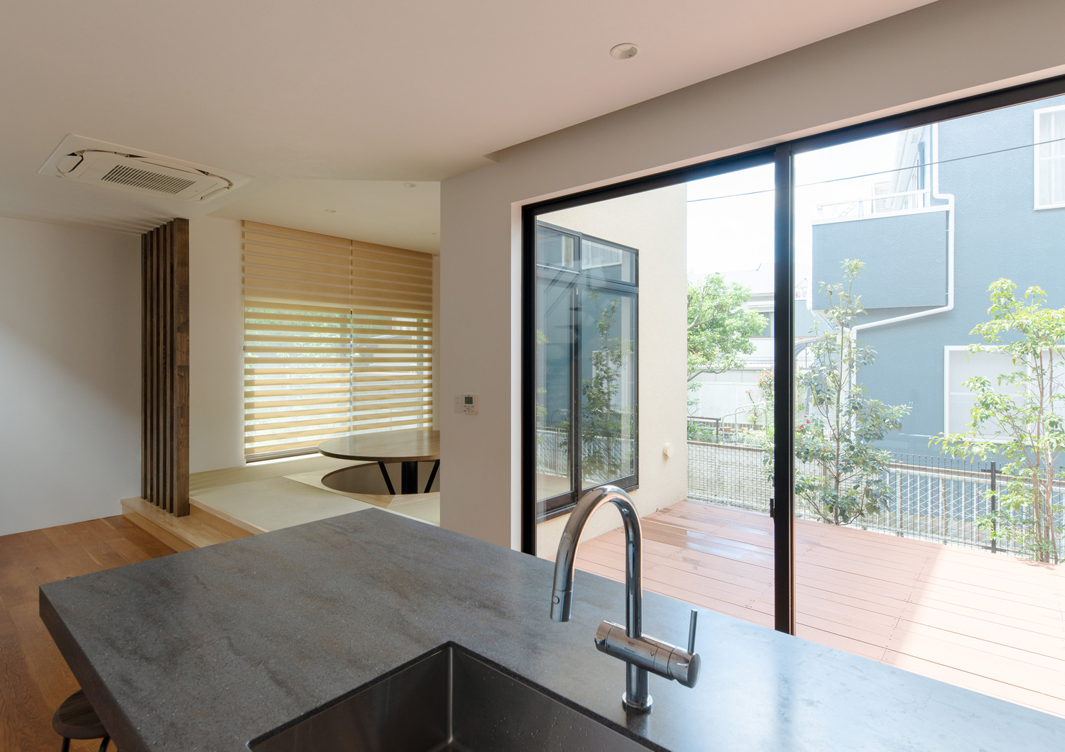 グレーのカウンターキッチンの正面に中庭が見えるLDK・デザイン住宅 注文住宅・デザイン住宅建築実例_『CASE637 『Assemble』』_LDK