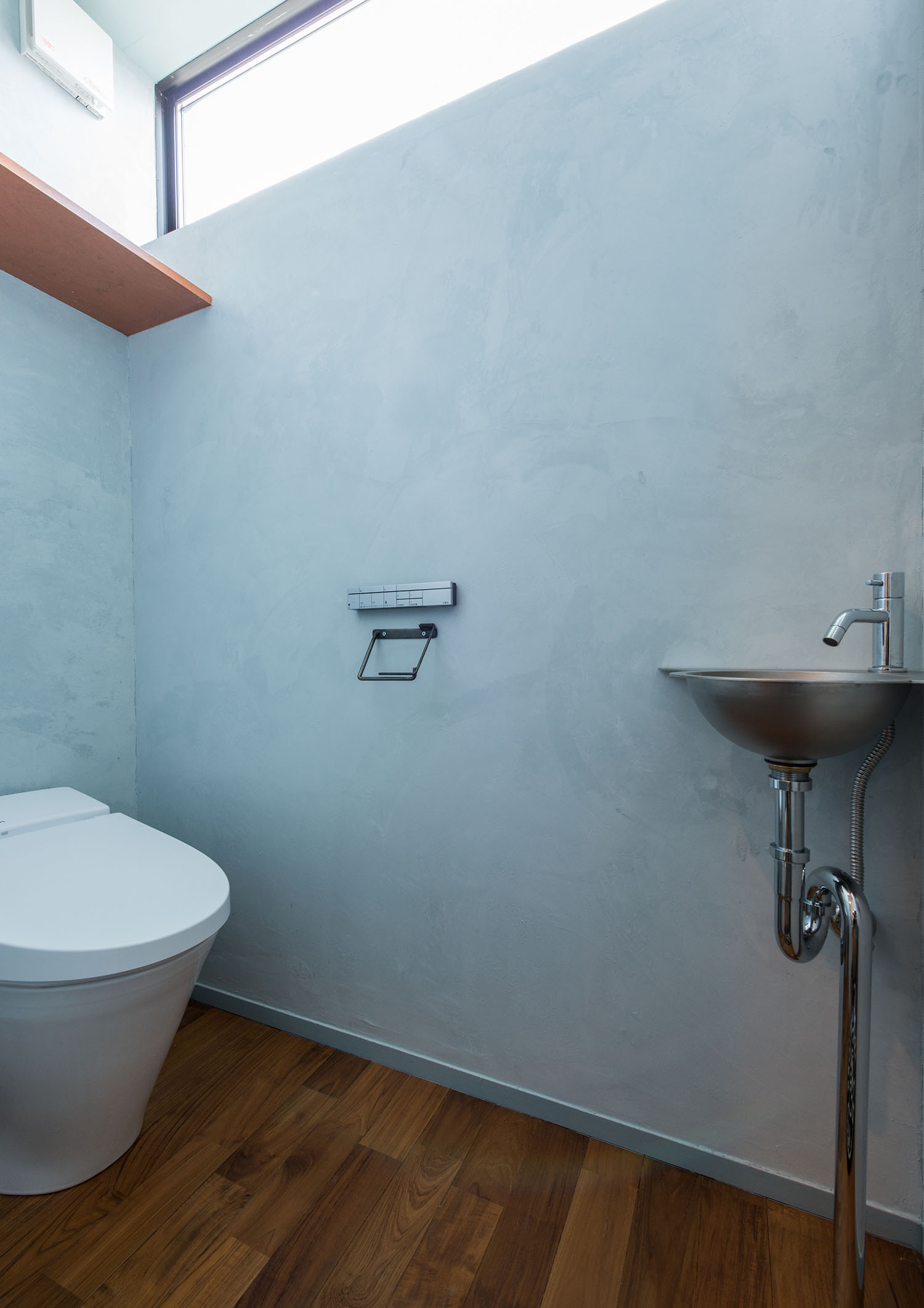 水色の壁で、ハイサイドライトがある手洗いカウンター付きのトイレ・デザイン住宅 注文住宅・デザイン住宅建築実例_『CASE631 こやのいえ』_トイレ