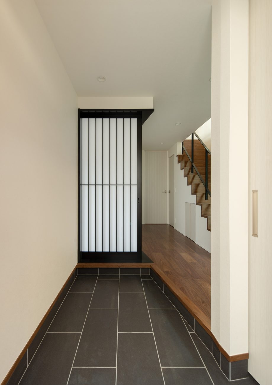 正面に黒枠の障子が見える、黒いタイルの玄関・デザイン住宅 注文住宅・デザイン住宅建築実例_『CASE639 Wall Side』_玄関