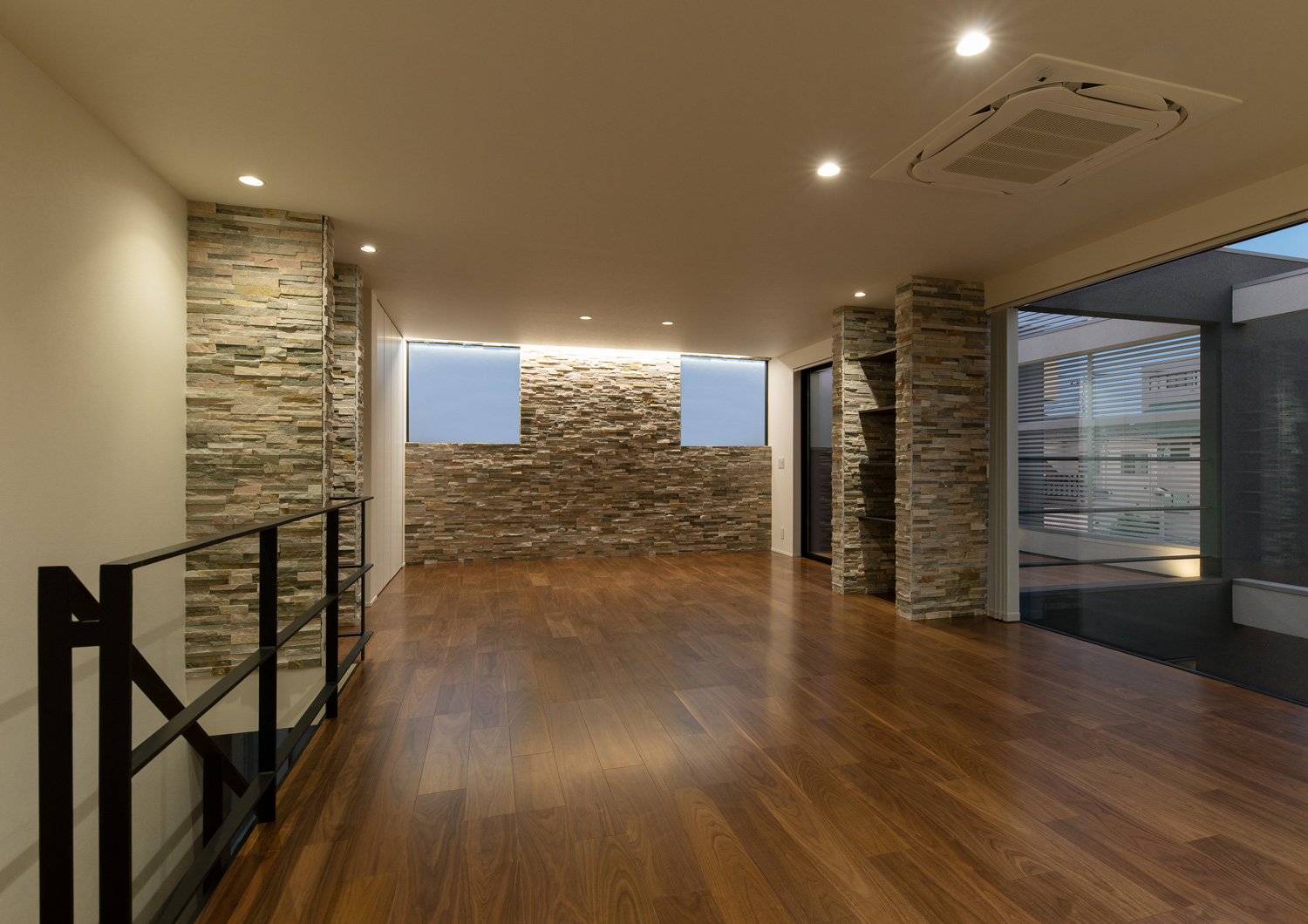 タイルの壁際に取り付けた間接照明と、天井のダウンライトに照らされるLDK・デザイン住宅 注文住宅・デザイン住宅建築実例_『CASE639 Wall Side』_LDK