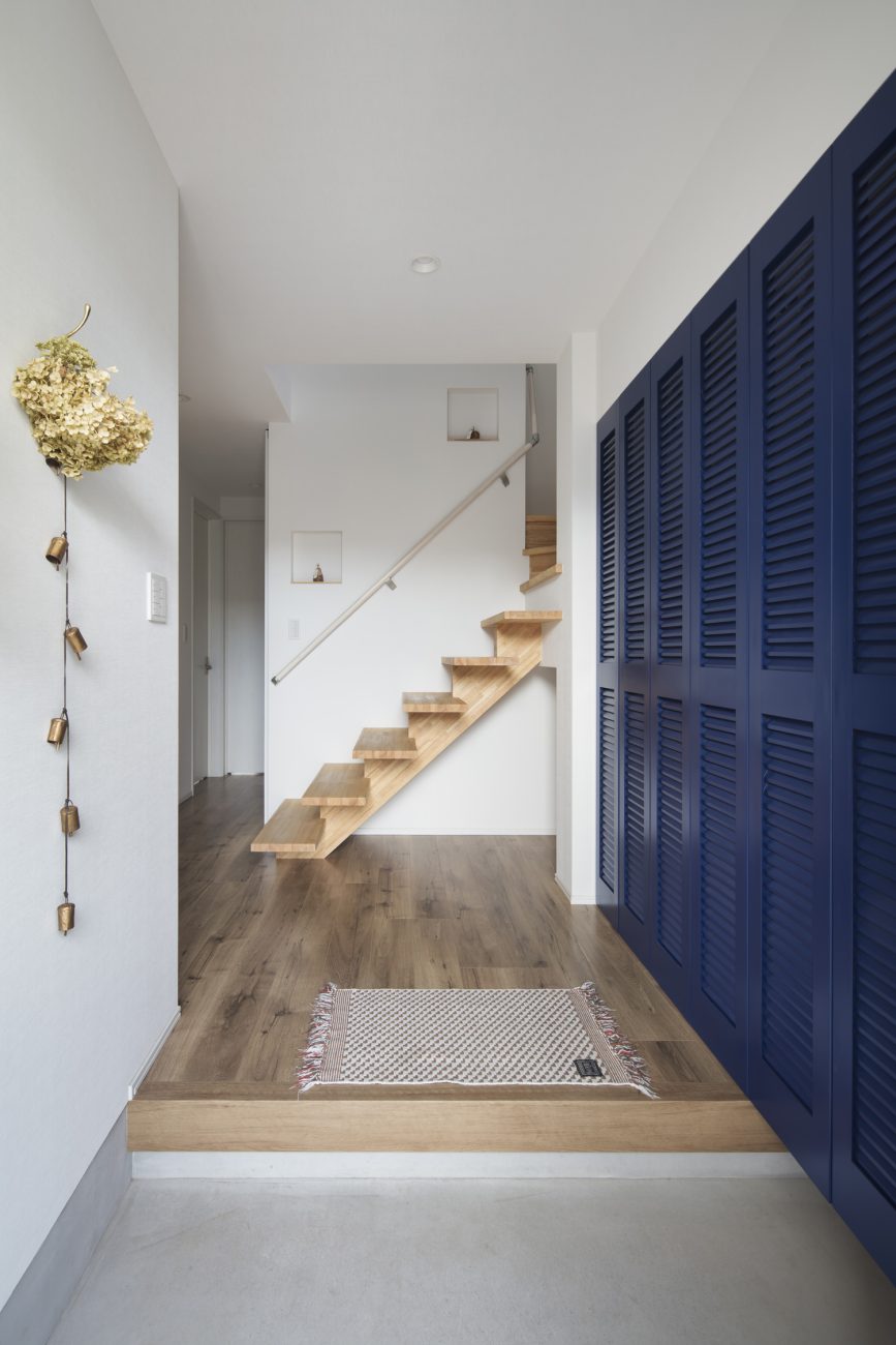 脇に青い扉があり、正面に木製のスケルトン階段がある玄関・デザイン住宅 注文住宅・デザイン住宅建築実例_『CASE640 nature』_玄関