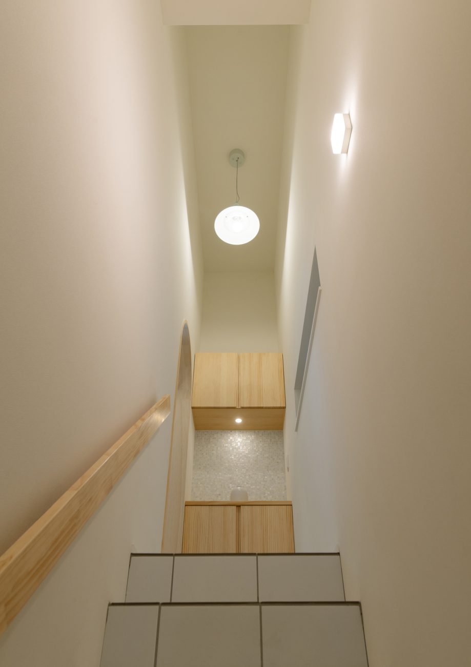 階段を上がった先に木の棚や丸いペンダントライトがある様子・デザイン住宅 注文住宅・デザイン住宅建築実例_『CASE641 だんだん』_玄関