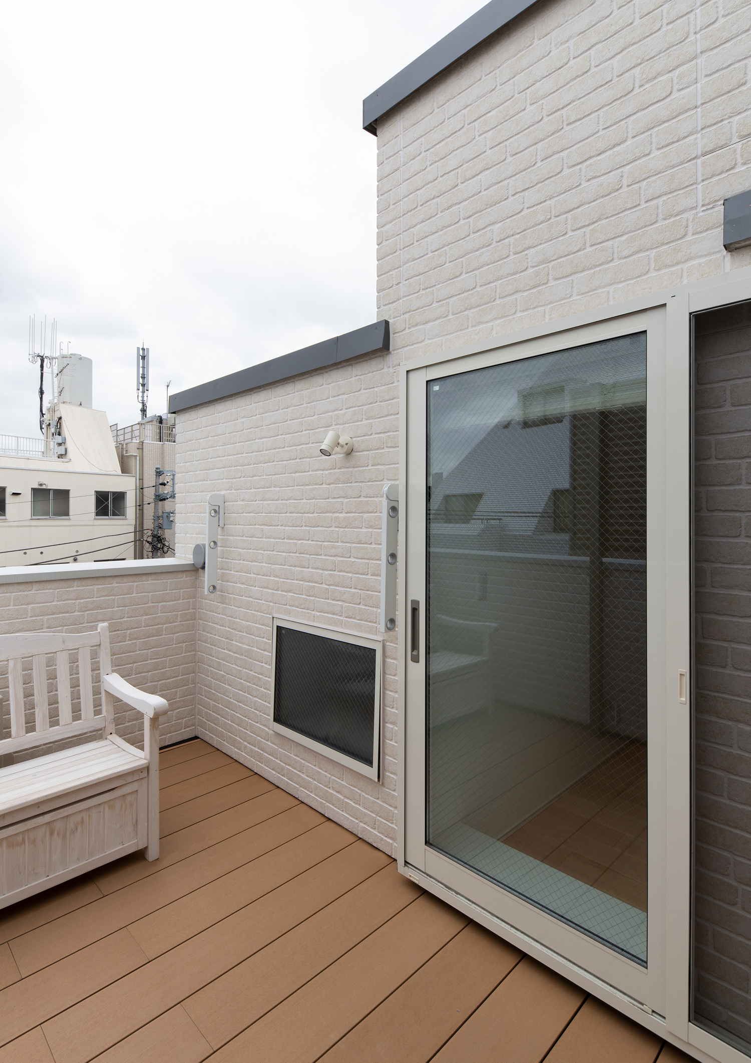 白いベンチが置かれたウッドデッキのルーフバルコニー・デザイン住宅 注文住宅・デザイン住宅建築実例_『CASE641 だんだん』_テラス・バルコニー