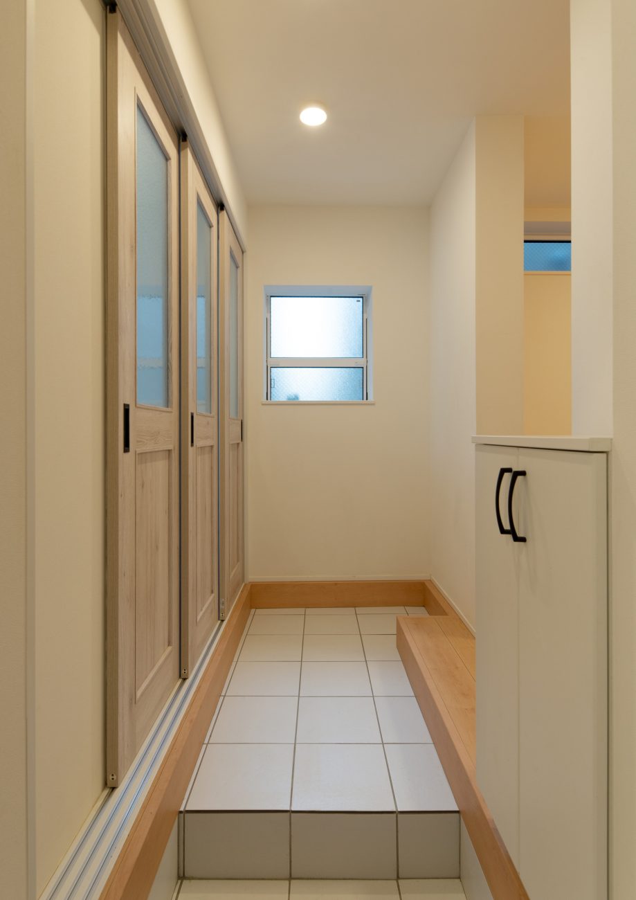 正面に小さな窓があるタイル張りの玄関・デザイン住宅 注文住宅・デザイン住宅建築実例_『CASE641 だんだん』_玄関