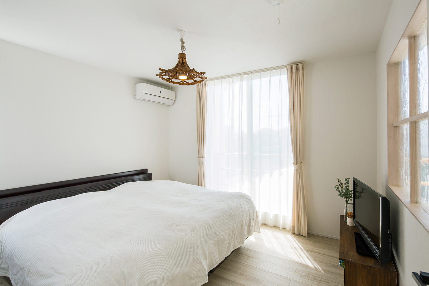 広いベッドの上にペンダントライトが取り付けられている寝室・デザイン住宅 注文住宅・デザイン住宅建築実例_『CASE635 三角屋根でつながる家』_寝室