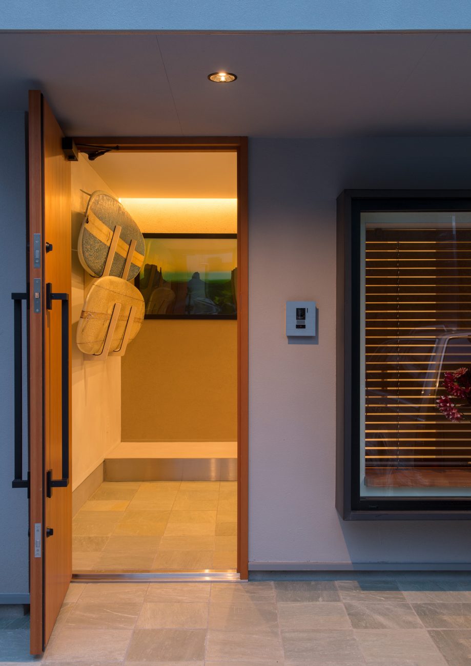 玄関扉が開けられ、外から壁にサーフボードが飾られた玄関が見える様子・デザイン住宅 注文住宅・デザイン住宅建築実例_『CASE643 だて窓のハウス』_外観