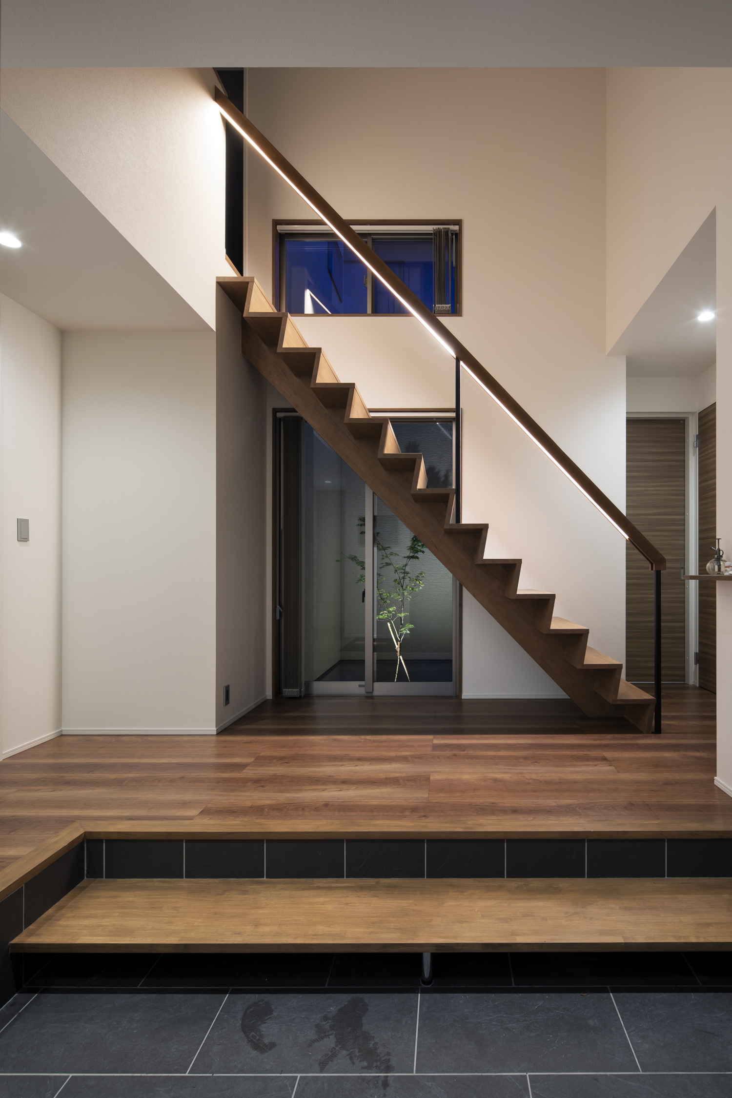 正面にスケルトン階段と植栽が見える窓がある玄関・デザイン住宅 注文住宅・デザイン住宅建築実例_『CASE644 Oasis』_玄関