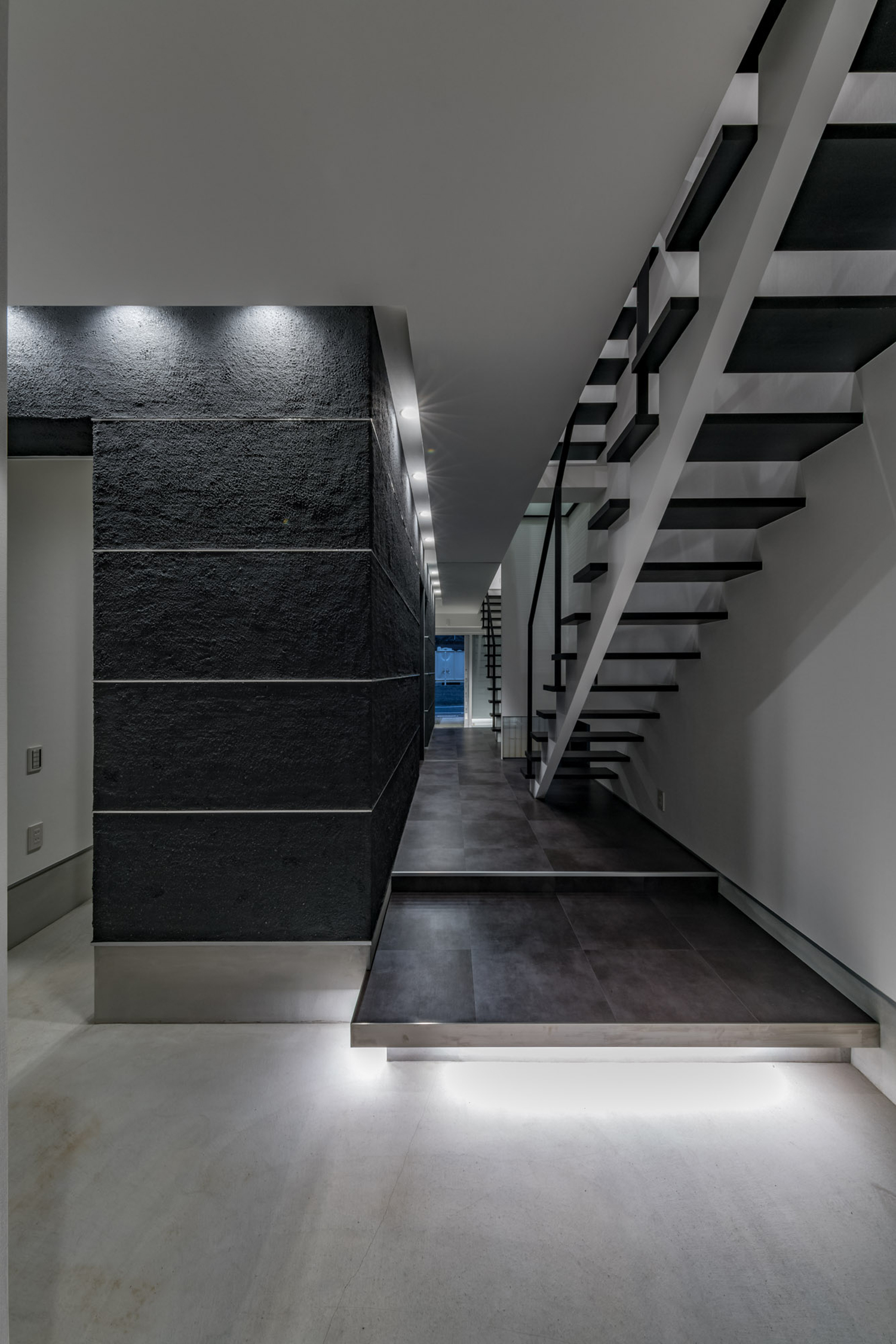 シューズインクローゼットが繋がる、足元に間接照明を取り付けたモルタルの玄関・デザイン住宅 注文住宅・デザイン住宅建築実例_『CASE646 鏡の家』_玄関