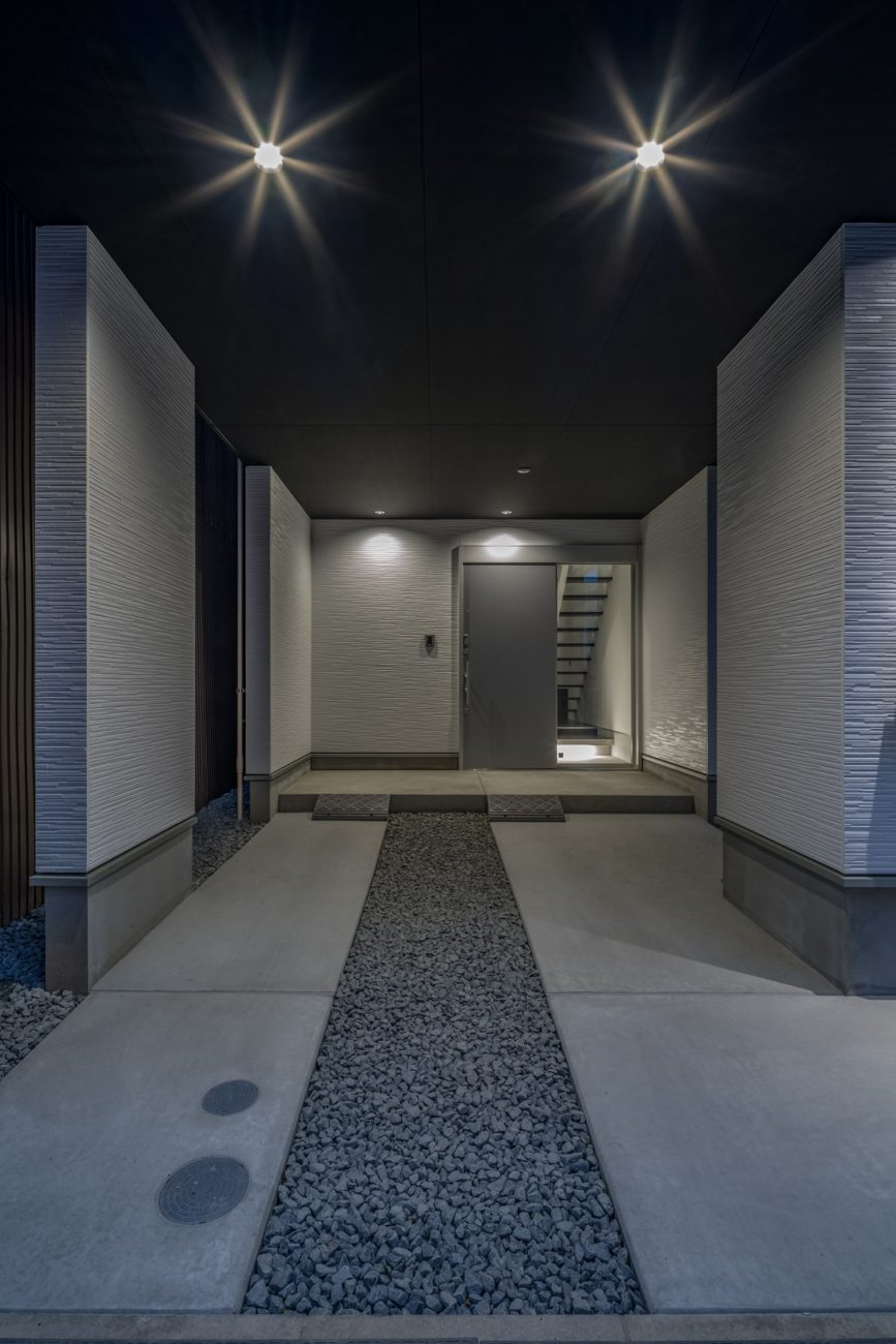 白い壁に囲まれ、黒い天井にはダウンライトが取り付けられたコンクリートの玄関ポーチ・デザイン住宅 注文住宅・デザイン住宅建築実例_『CASE646 鏡の家』_外観