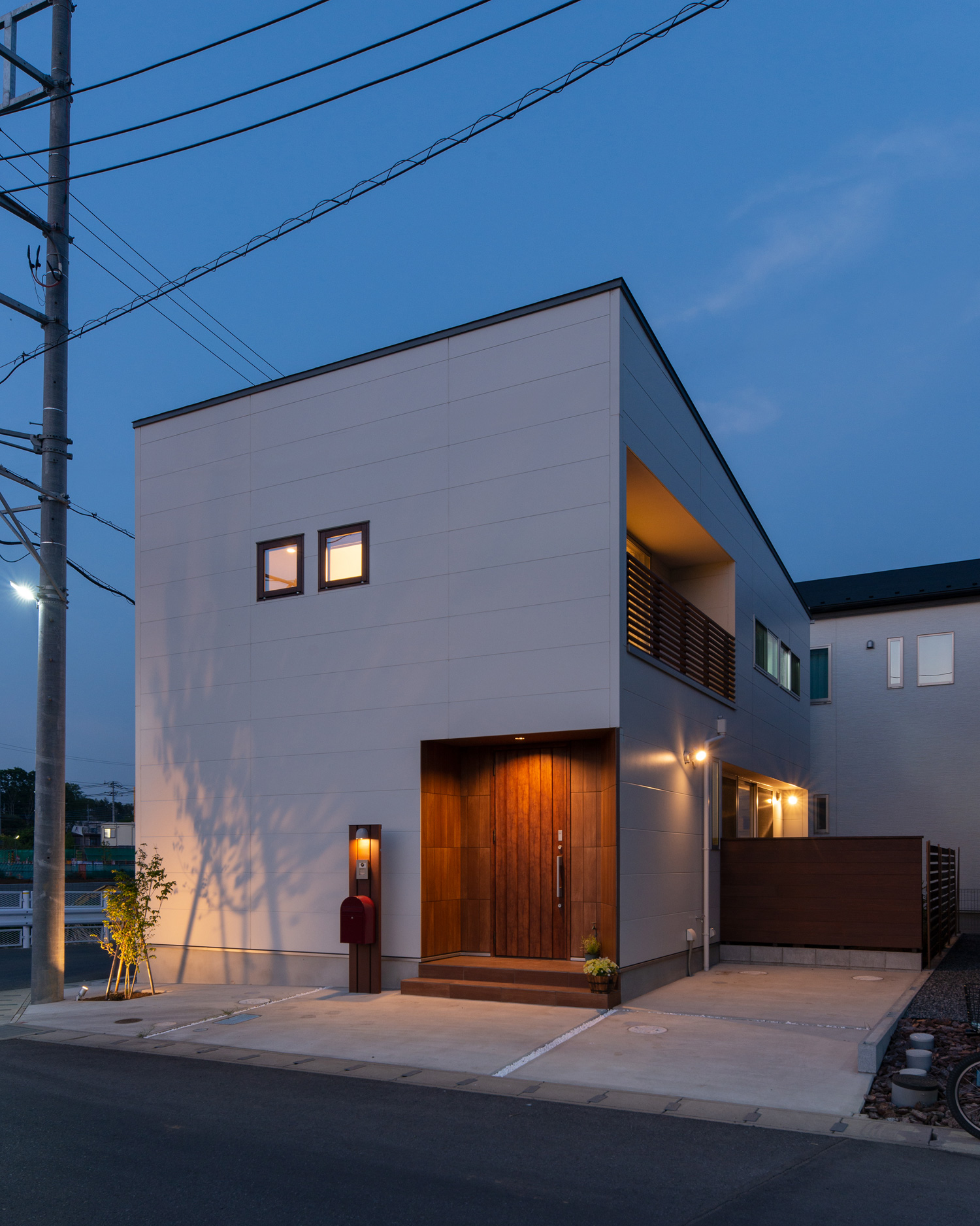 小さな窓や玄関回りの照明に照らされる白い外壁の住宅・デザイン住宅 注文住宅・デザイン住宅建築実例_『CASE647 ニコニコハウス』_外観