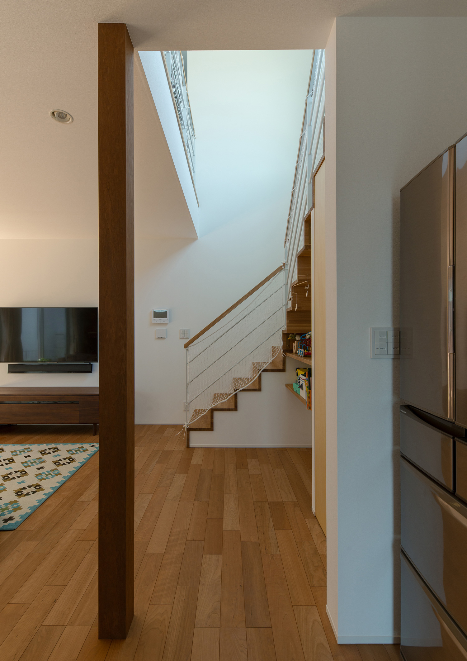 リビングイン階段部分が吹き抜けになっているフローリングのLDK・デザイン住宅 注文住宅・デザイン住宅建築実例_『CASE647 ニコニコハウス』_LDK