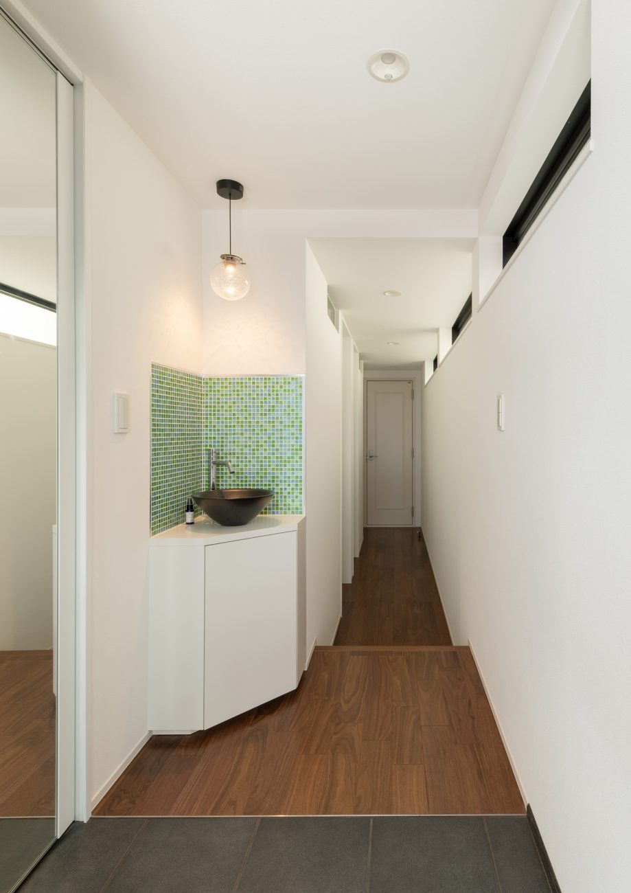 緑のタイルの壁がアクセントになった手洗いカウンターがある玄関・デザイン住宅 注文住宅・デザイン住宅建築実例_『CASE648 白鍵の家』_玄関