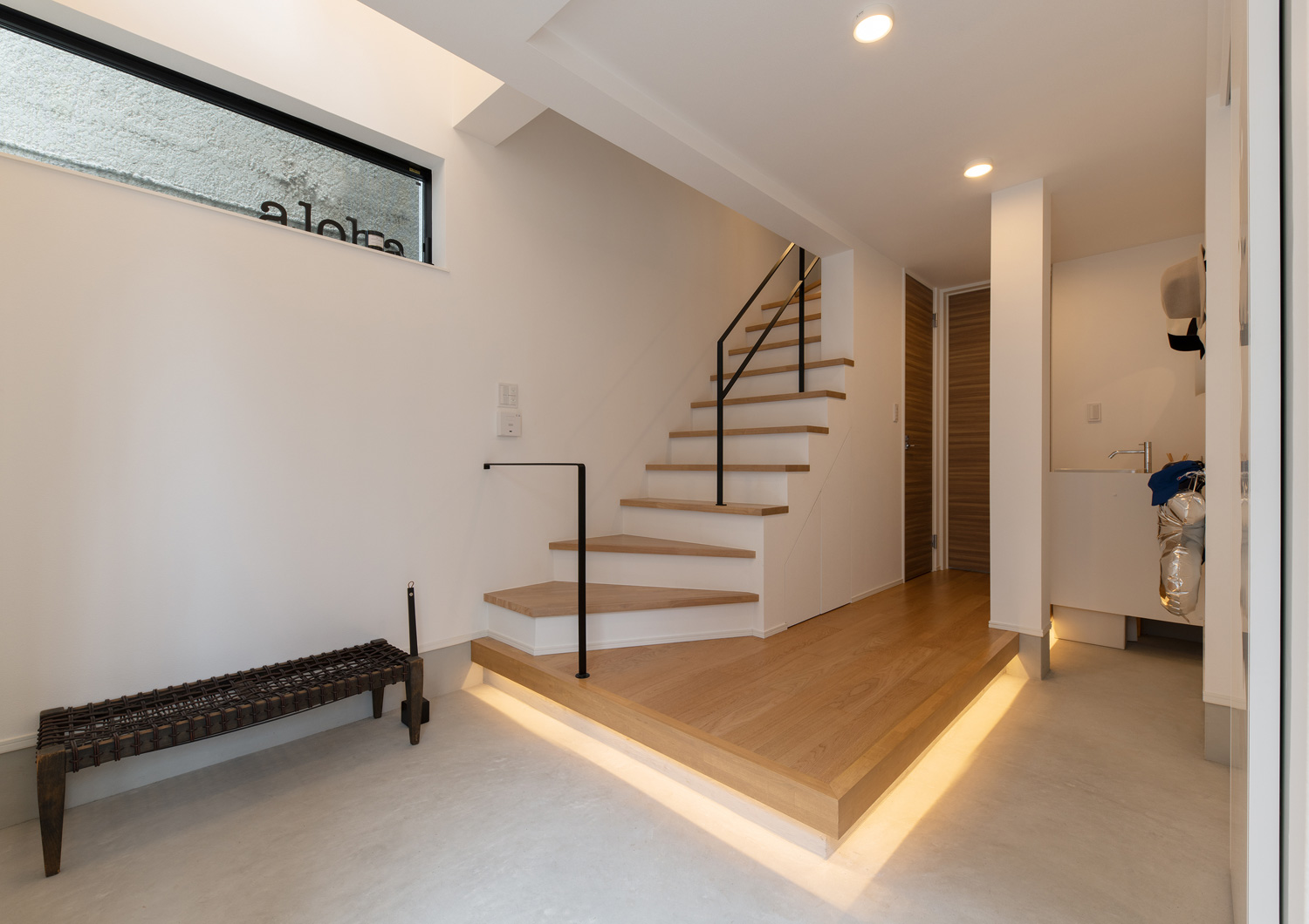 段差に間接照明が取り付けられたモルタルの土間玄関・デザイン住宅 注文住宅・デザイン住宅建築実例_『CASE651 New_tral House』_玄関