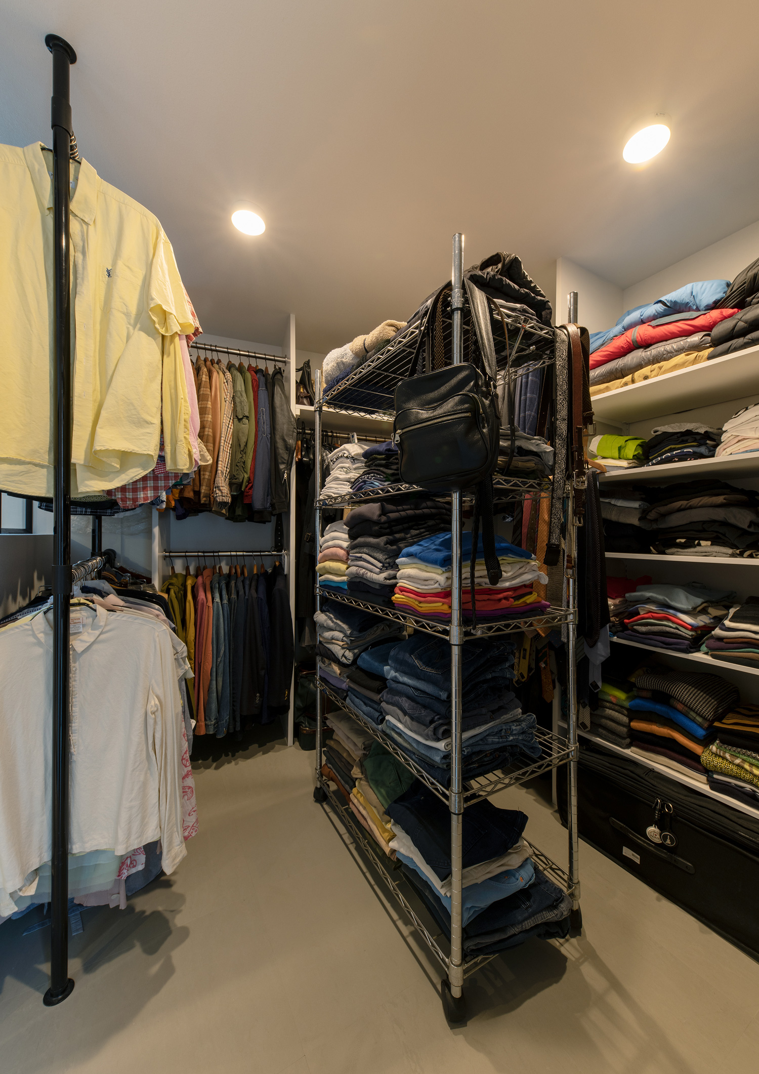 シルバーラックやハンガーにかけられた服があるウォークインクローゼット・デザイン住宅 注文住宅・デザイン住宅建築実例_『CASE651 New_tral House』_玄関