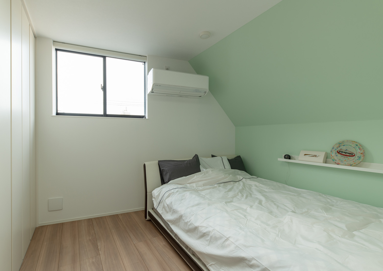 ミントグリーンのアクセントクロスを設けた母屋下がりの寝室・デザイン住宅 注文住宅・デザイン住宅建築実例_『CASE651 New_tral House』_寝室
