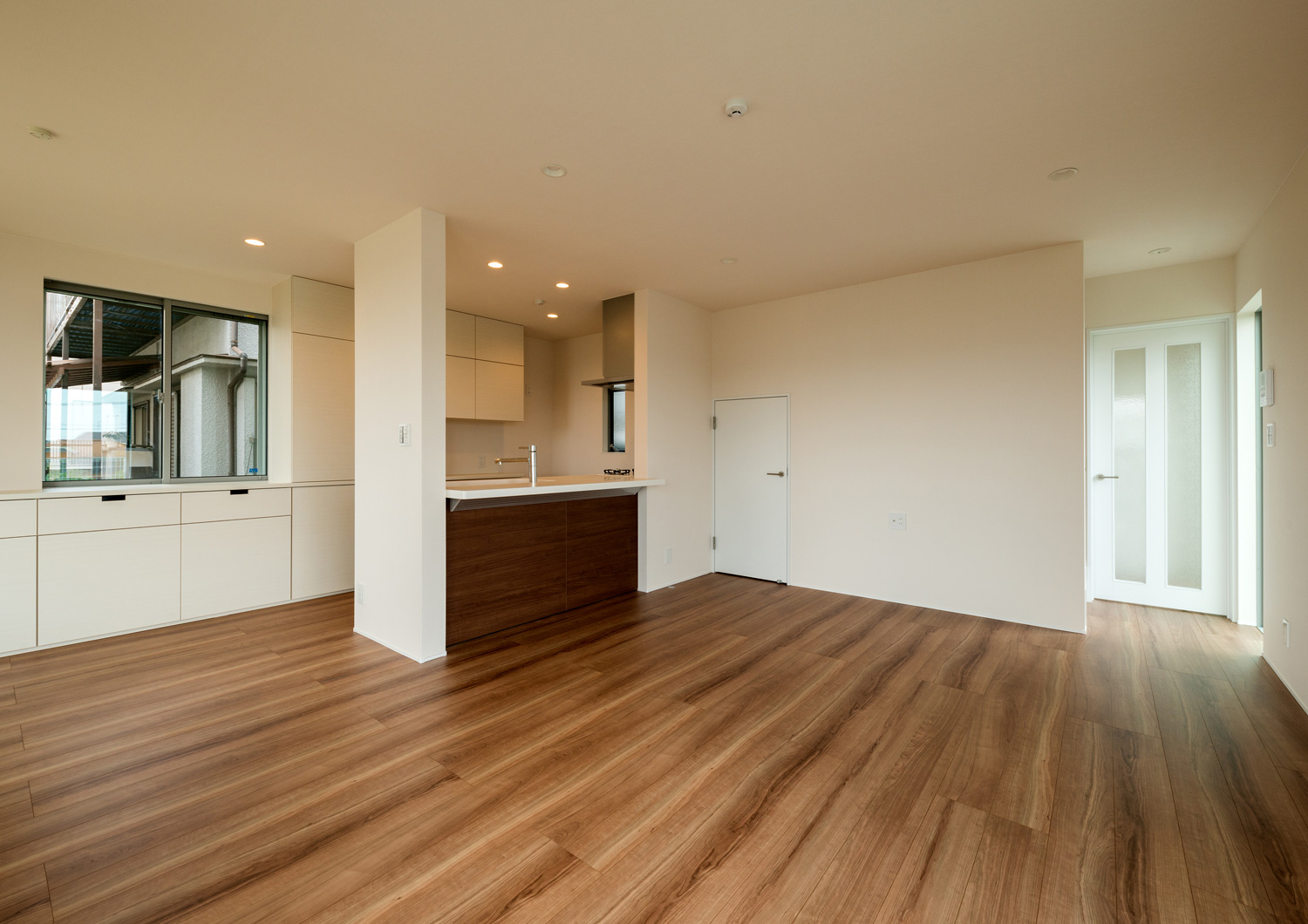 カウンターが取り付けられたペニンシュラキッチンがあるフローリングのLDK・デザイン住宅 注文住宅・デザイン住宅建築実例_『CASE650 景色を持つ家』_LDK