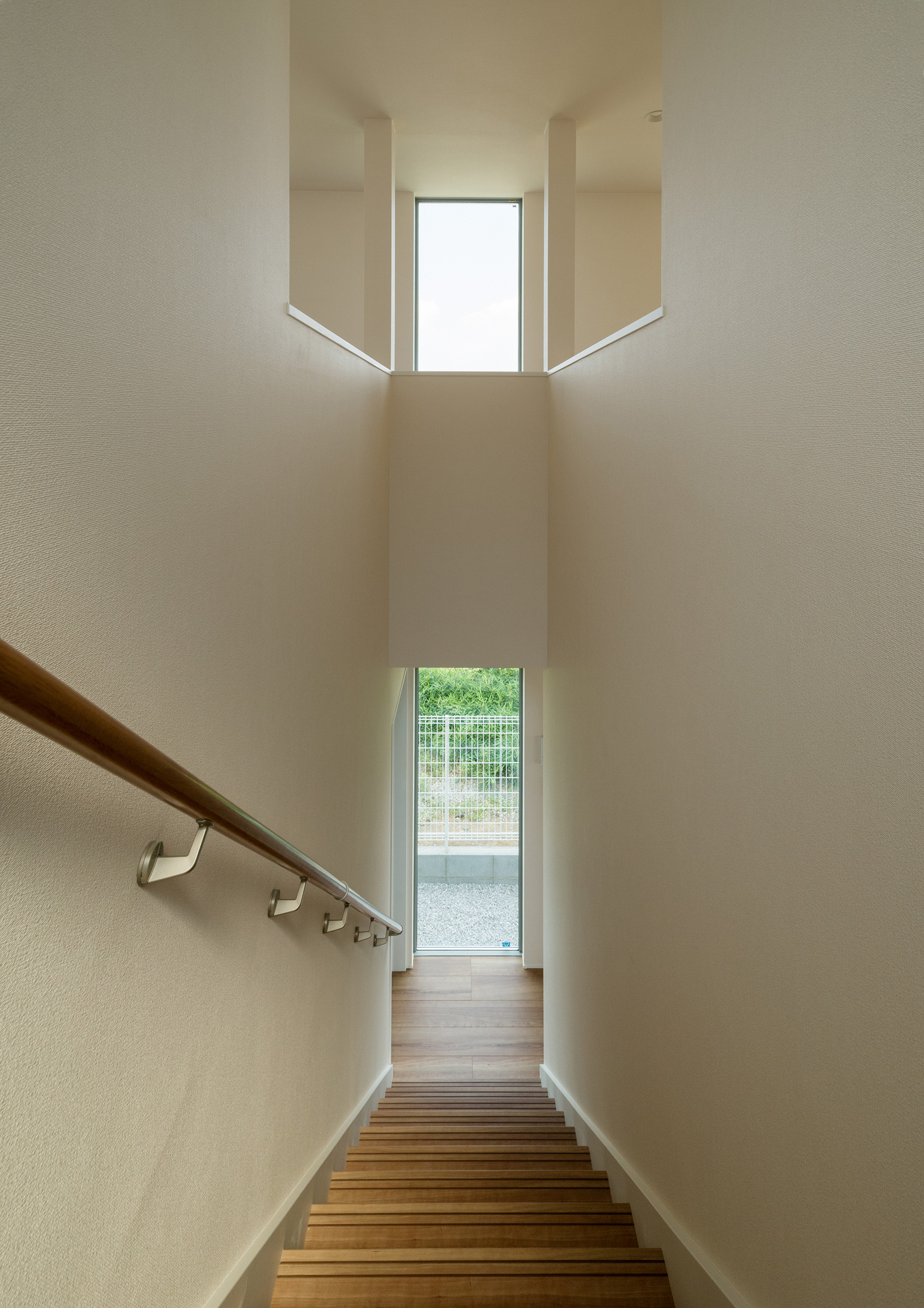 正面に窓がある白い壁に囲まれた木製の階段・デザイン住宅 注文住宅・デザイン住宅建築実例_『CASE650 景色を持つ家』_階段