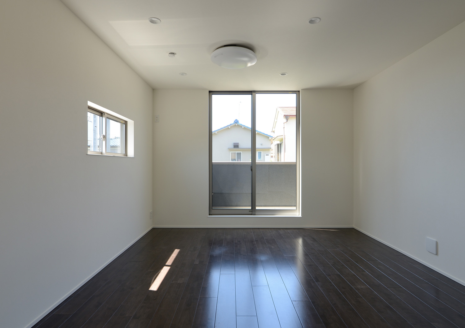 ベランダに続く窓がある濃い色のフローリングの個室・デザイン住宅 注文住宅・デザイン住宅建築実例_『CASE652 2つの吹抜けを持つ家。』_寝室