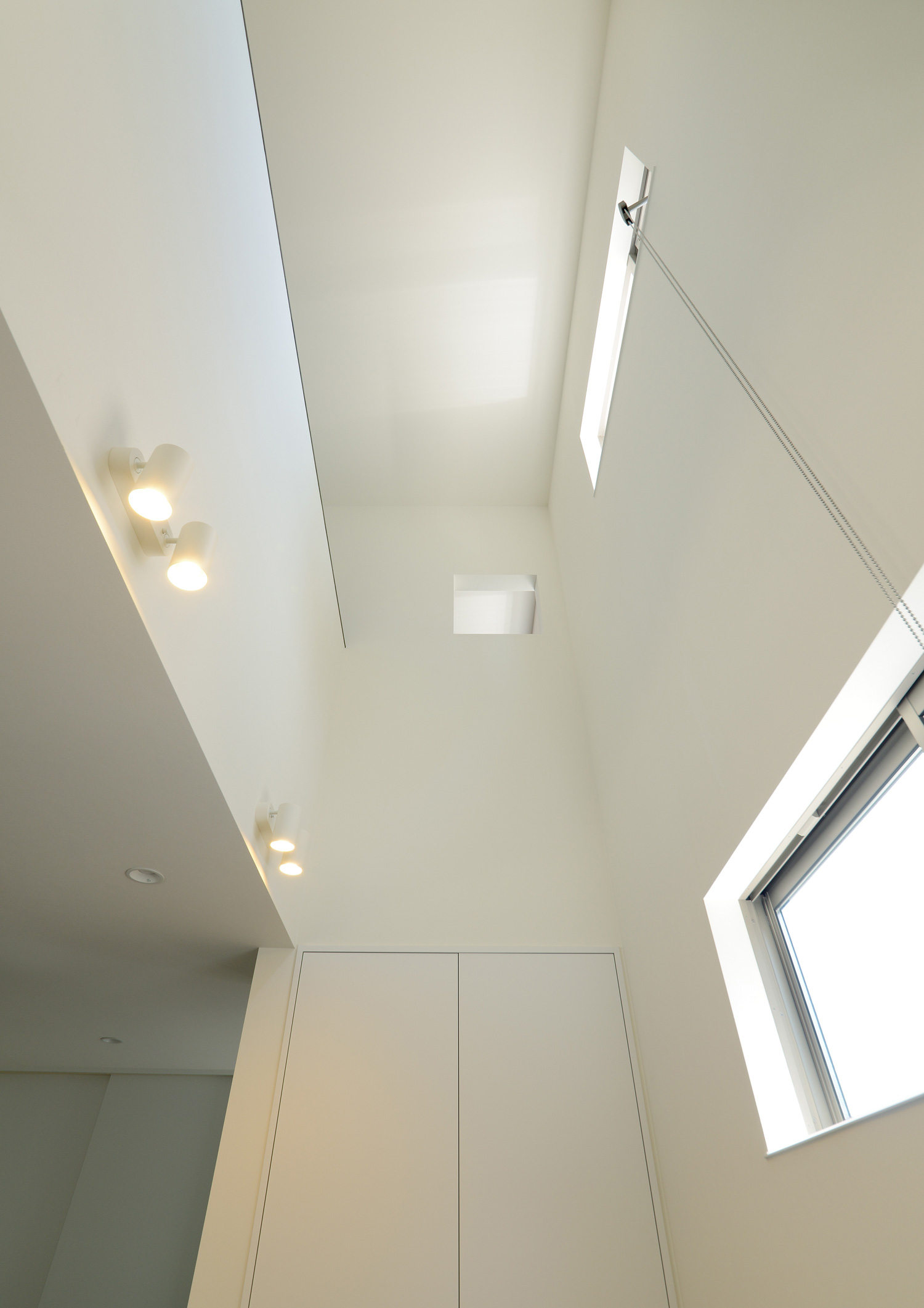 白い壁で、窓が設けられた吹き抜け・デザイン住宅 注文住宅・デザイン住宅建築実例_『CASE652 2つの吹抜けを持つ家。』_LDK