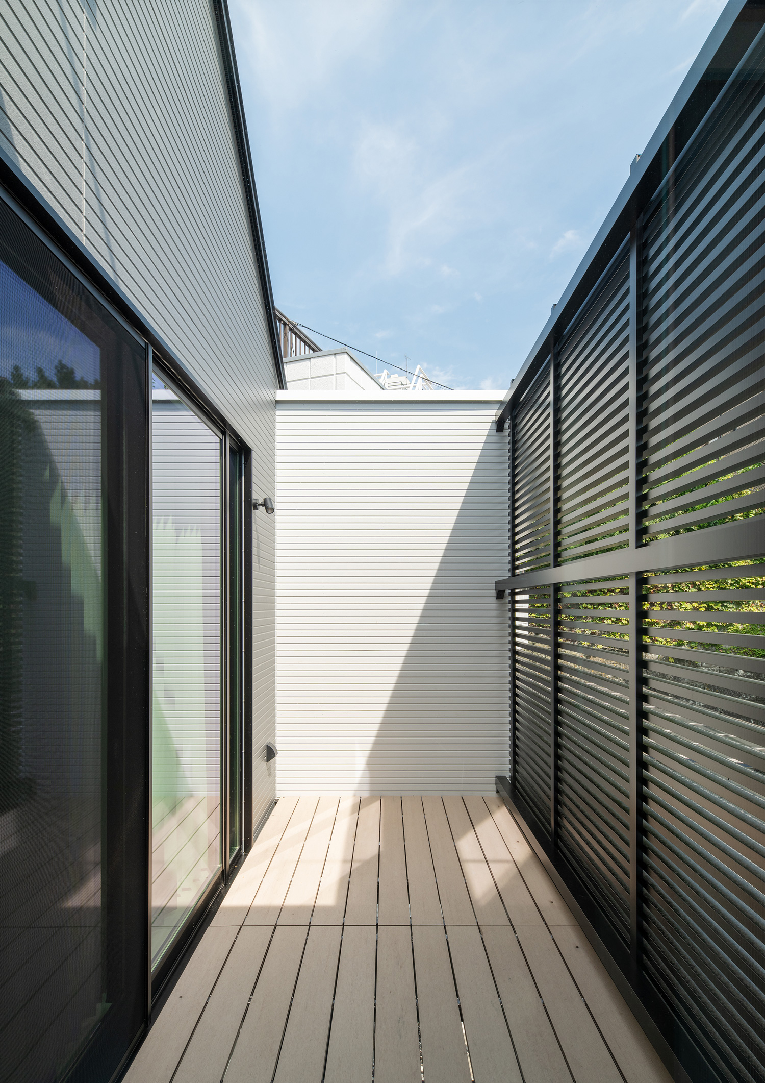 ウッドデッキのベランダに黒い目隠しフェンスが立てられている様子・デザイン住宅 注文住宅・デザイン住宅建築実例_『CASE653 せんのいえ』_テラス・バルコニー