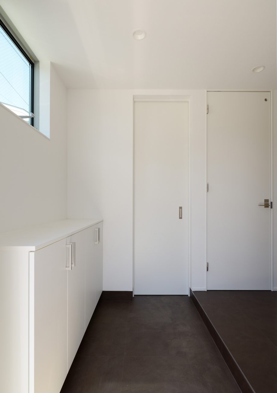 床が黒く、壁や建具が白で統一された玄関・デザイン住宅 注文住宅・デザイン住宅建築実例_『CASE654 circulating』_玄関