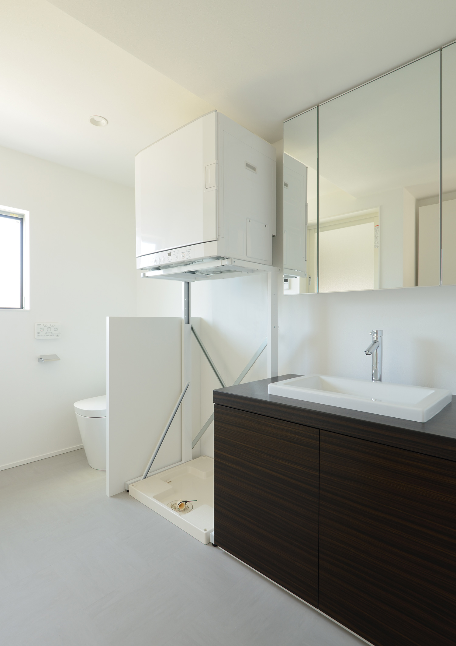 洗面台の隣に洗濯機を置くスペースがあり、さらにその先にトイレがある空間・デザイン住宅 注文住宅・デザイン住宅建築実例_『CASE654 circulating』_浴室・洗面所