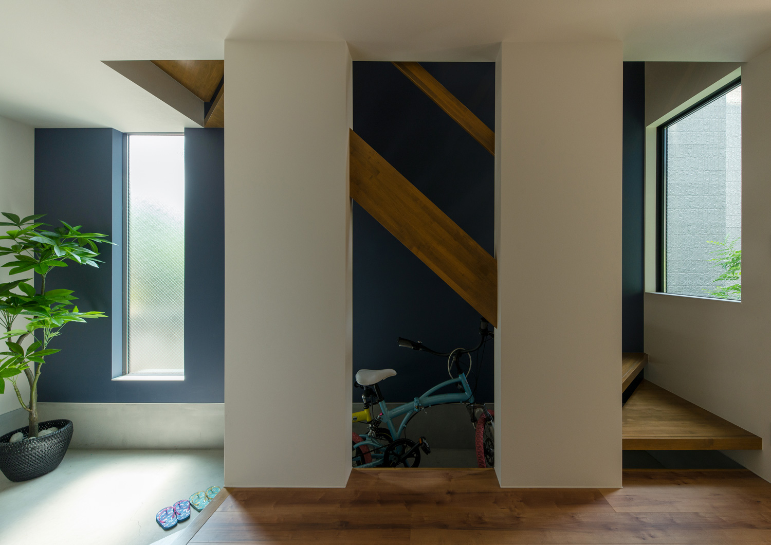 土間の玄関を横切るように木製のスケルトン階段がある様子・デザイン住宅 注文住宅・デザイン住宅建築実例_『CASE655 群青』_階段