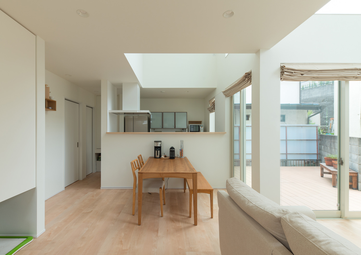 白い腰壁付きにキッチンの前に木のダイニングテーブルが置かれたLDK・デザイン住宅 注文住宅・デザイン住宅建築実例_『CASE580 cherishing house』_LDK