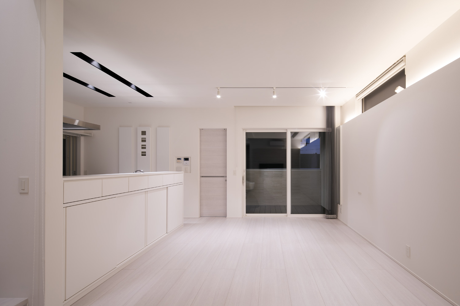 壁の間接照明や、天井のスポットライトによって照らされる真っ白なLDK・デザイン住宅 注文住宅・デザイン住宅建築実例_『CASE656 L x』_LDK