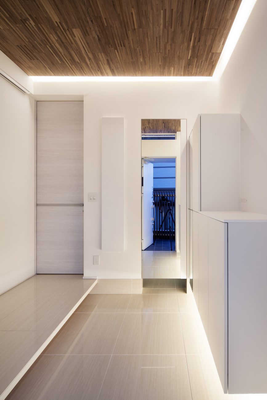 扉の正面に鏡がある、タイル張りの床で木目の天井の玄関・デザイン住宅 注文住宅・デザイン住宅建築実例_『CASE656 L x』_玄関