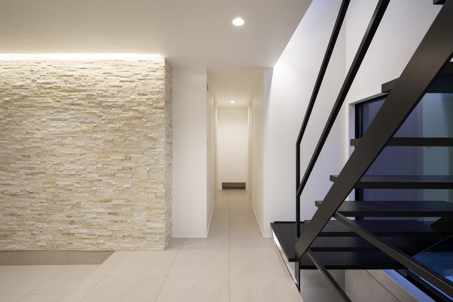 黒いスケルトン階段がある白いタイルの床の玄関・デザイン住宅 注文住宅・デザイン住宅建築実例_『CASE657 La scene』_玄関