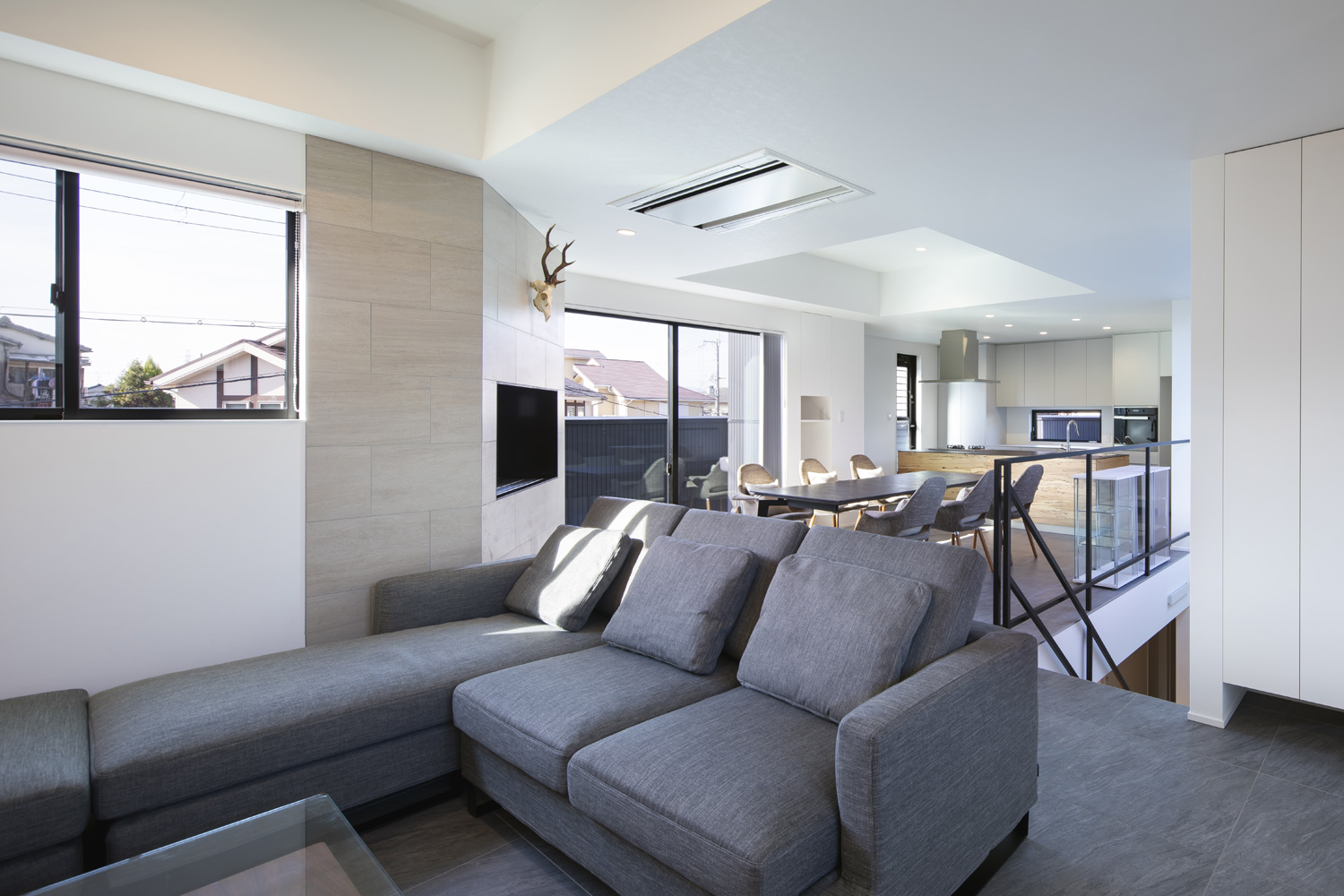 黒いタイルの床で、グレーのL字ソファーがあるLDK・デザイン住宅 注文住宅・デザイン住宅建築実例_『CASE657 La scene』_LDK