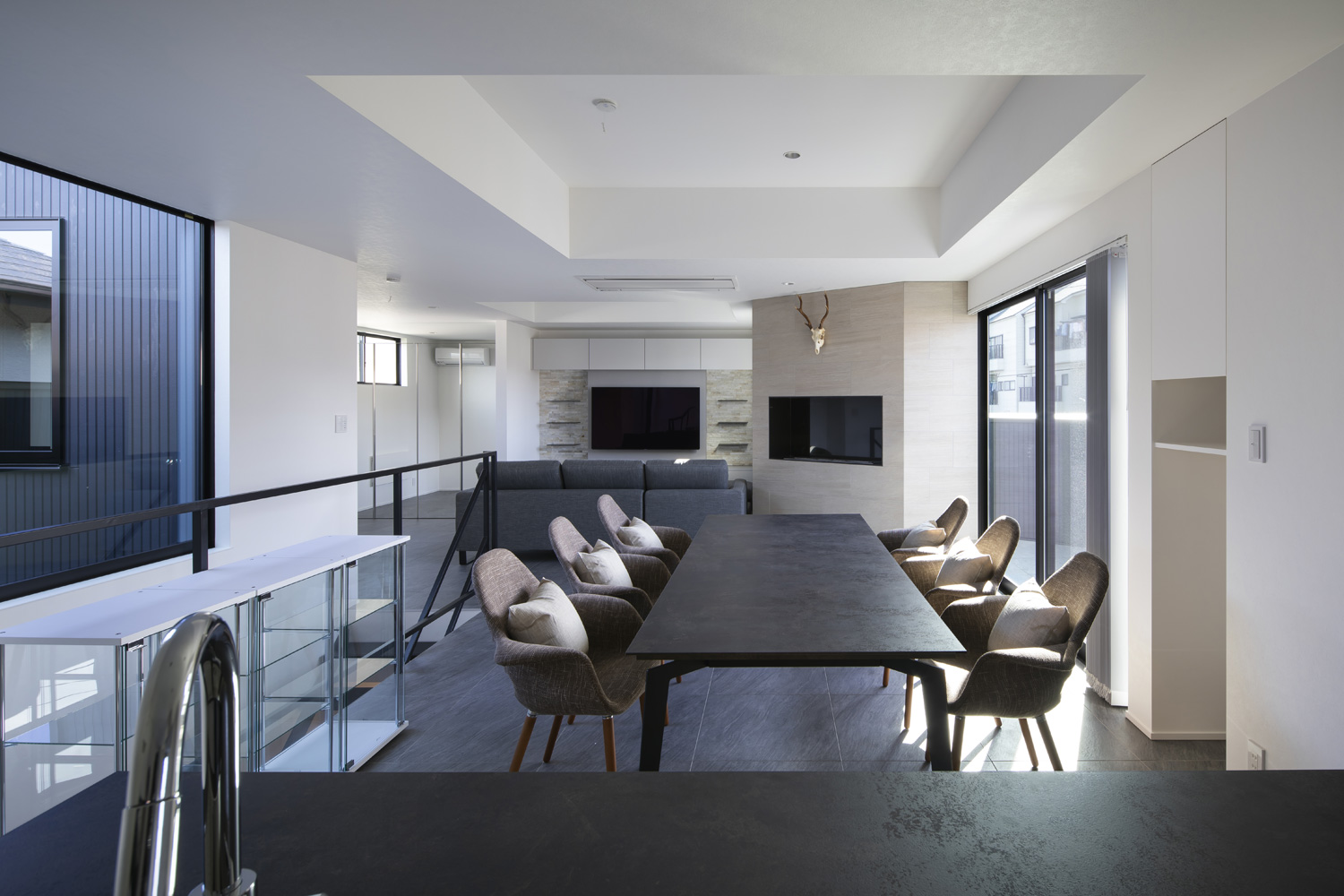 アイランドキッチンから、六人掛けのダイニングテーブルやL字ソファーのあるリビングが見える様子・デザイン住宅 注文住宅・デザイン住宅建築実例_『CASE657 La scene』_LDK