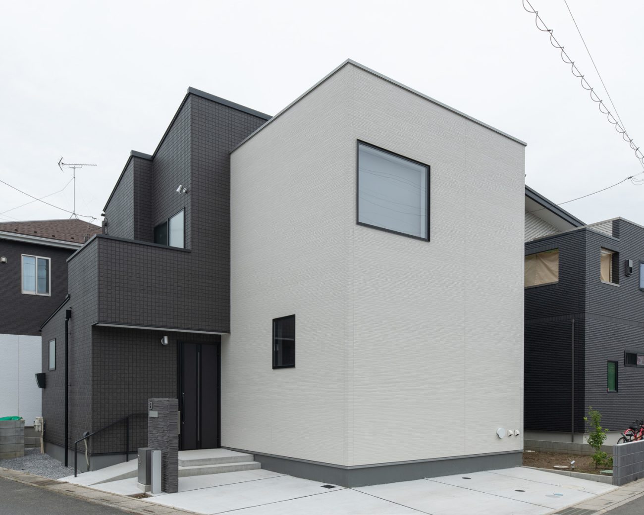白と黒の外壁で、窓が少ない角地の住宅・デザイン住宅 注文住宅・デザイン住宅建築実例_『CASE658 connecting terminal』_外観