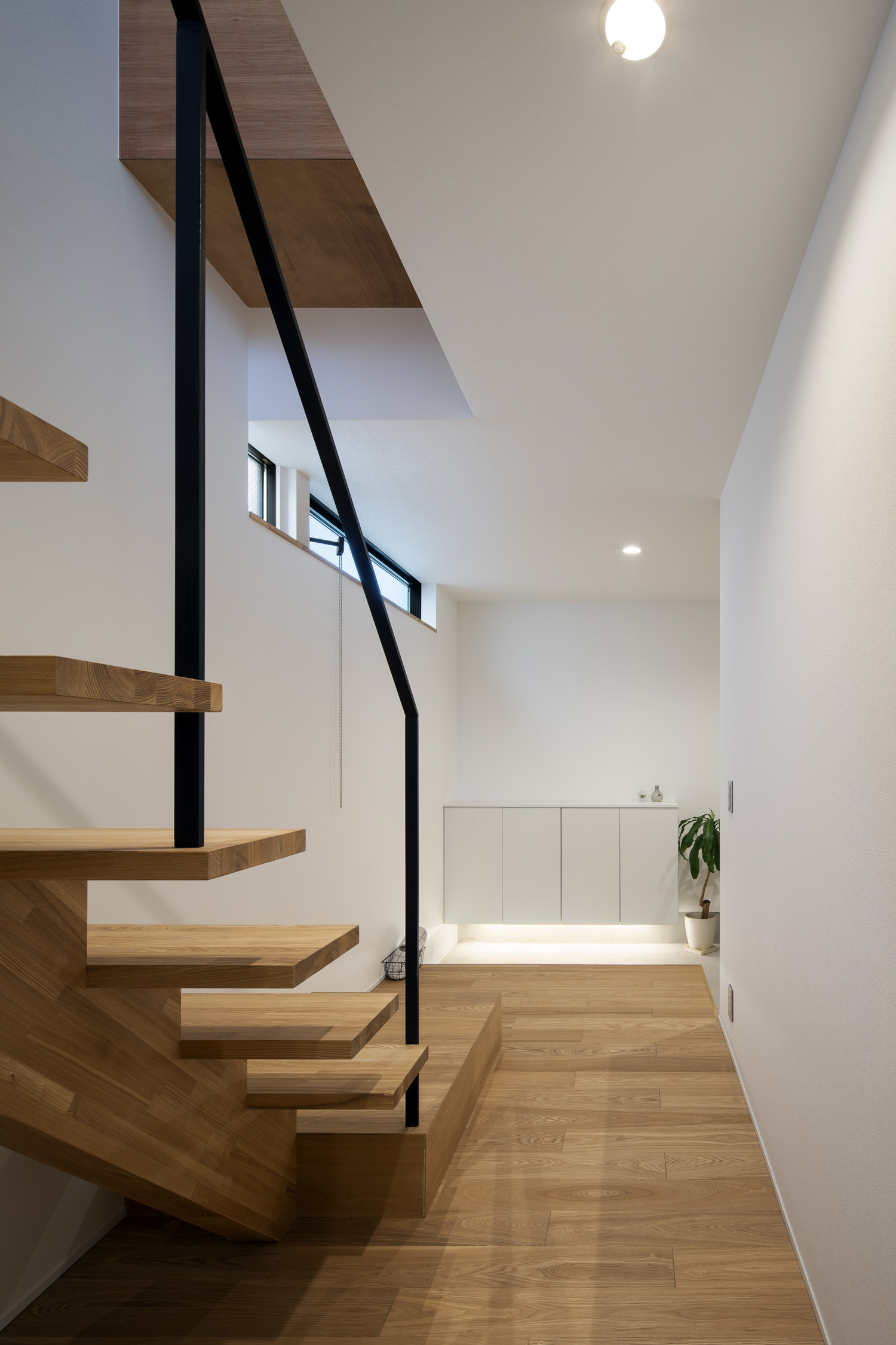 フローリングのフロアと同じ素材のスケルトン階段が設けられた空間・デザイン住宅 注文住宅・デザイン住宅建築実例_『CASE659 un cube』_玄関