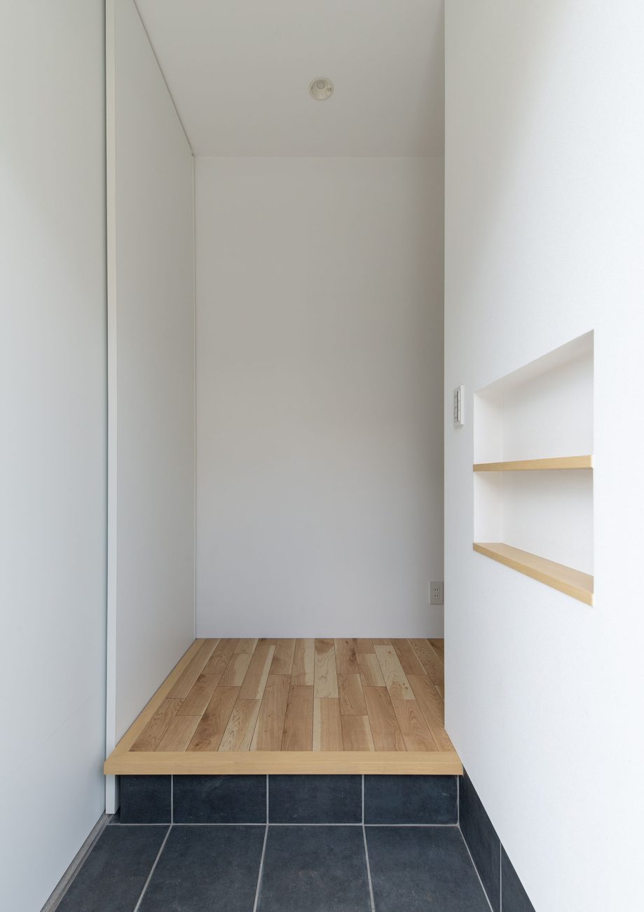 白い壁に囲まれた黒いタイル張りの玄関・デザイン住宅 注文住宅・デザイン住宅建築実例_『CASE660 Marine et grille』_玄関