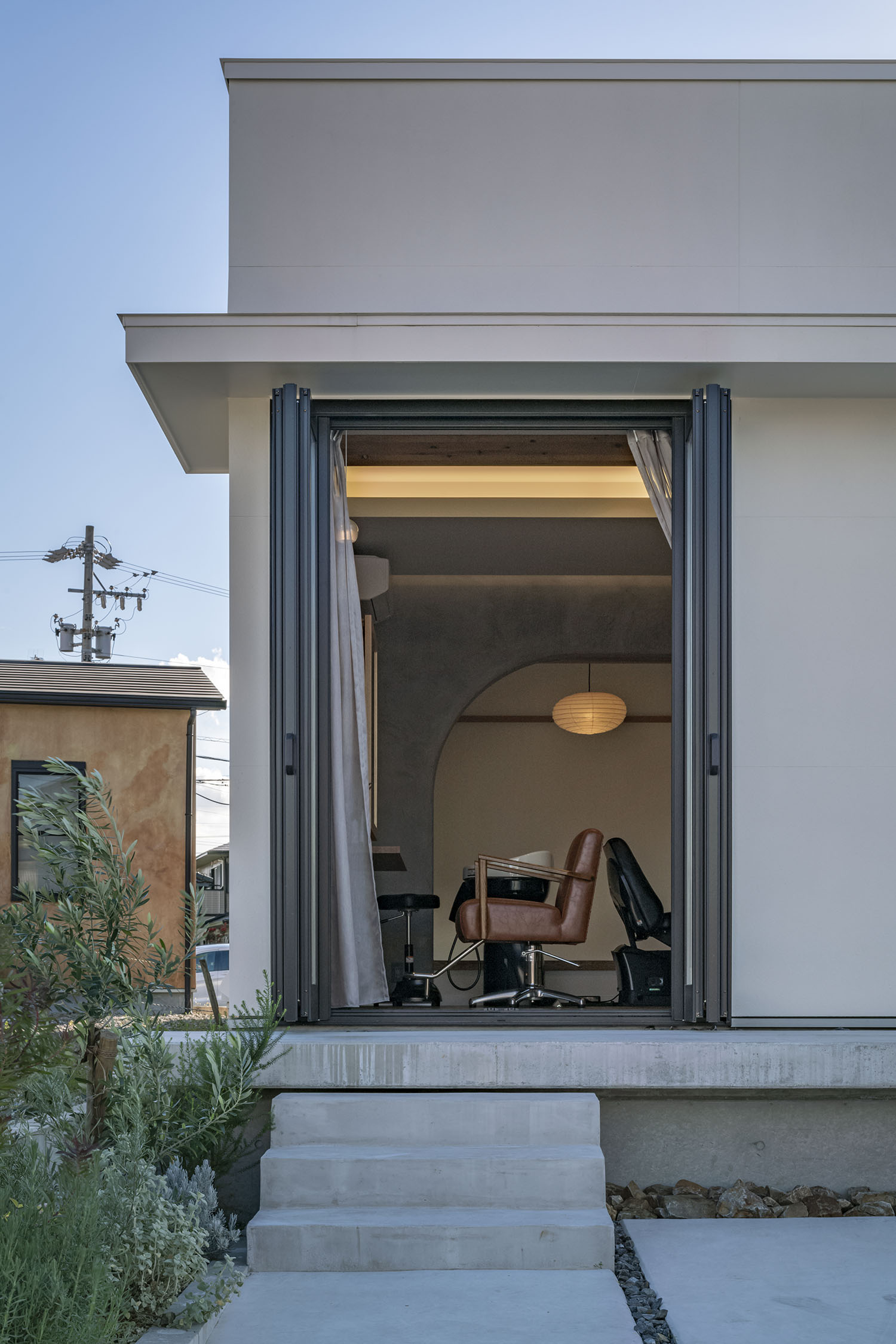 コンクリートの階段を上がった先の窓から室内へと繋がる様子・デザイン住宅 注文住宅・デザイン住宅建築実例_『CASE661 環(めぐる)いえ』_外観