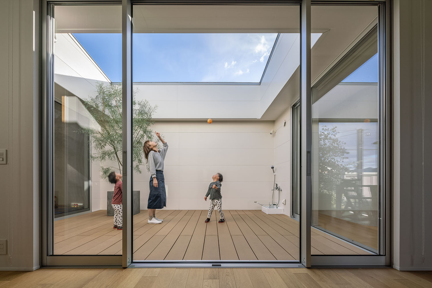 ウッドデッキの中庭で、親子が空を見上げている様子・デザイン住宅 注文住宅・デザイン住宅建築実例_『CASE661 環(めぐる)いえ』_中庭
