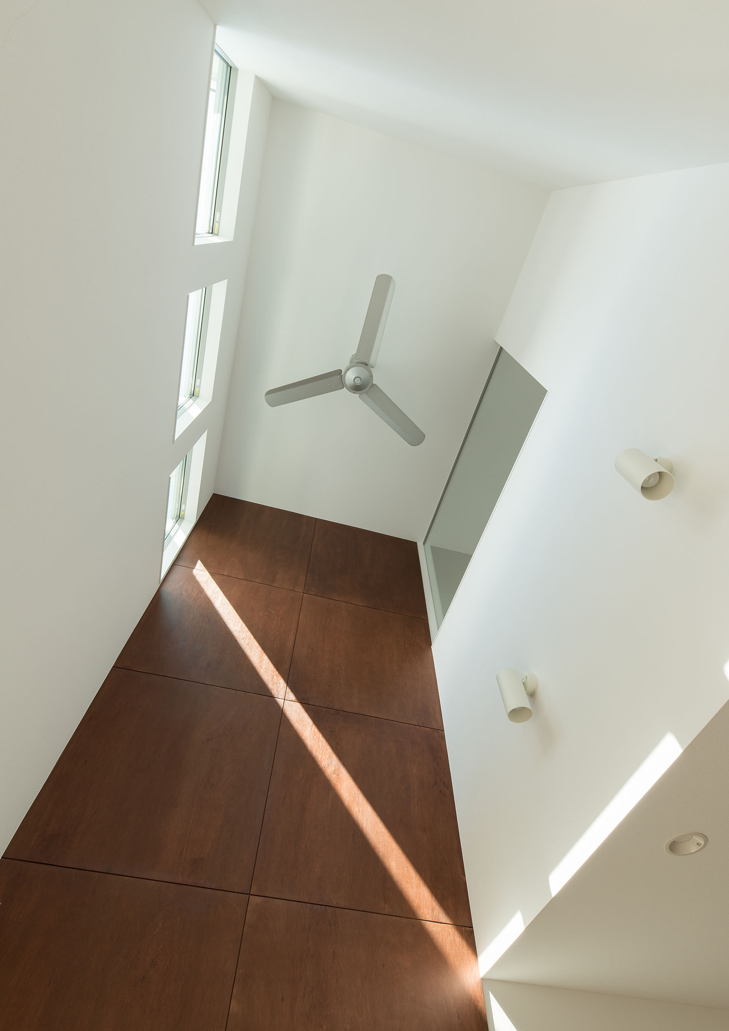 木目のアクセントウォールになった吹き抜け上部に取り付けられたシーリングファン・デザイン住宅 注文住宅・デザイン住宅建築実例_『CASE662 まくのいえ』_LDK